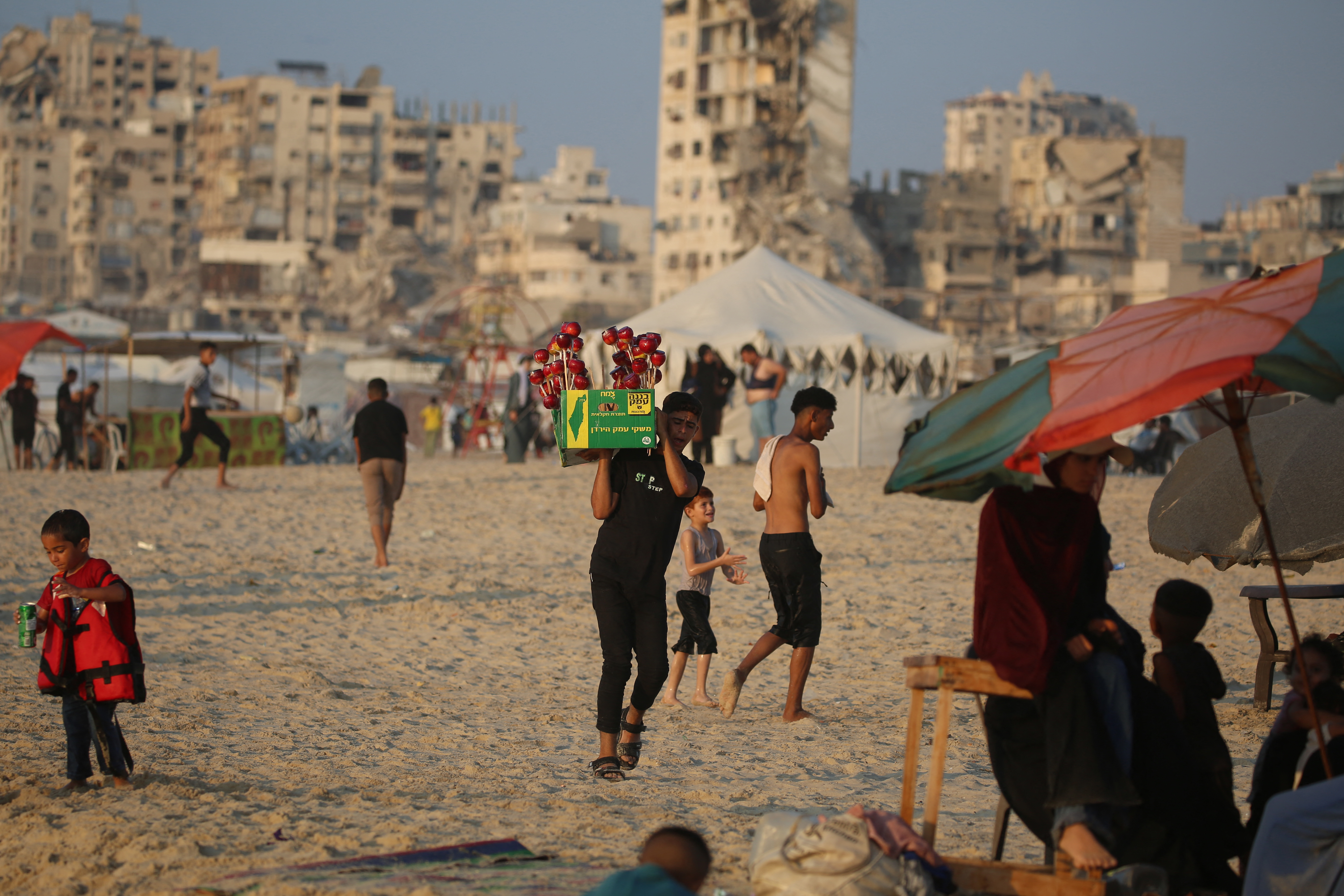 Displaced Palestinians gather along on the beach front in Gaza City on August 14, 2026. (Photo by Eyad Baba / AFP)