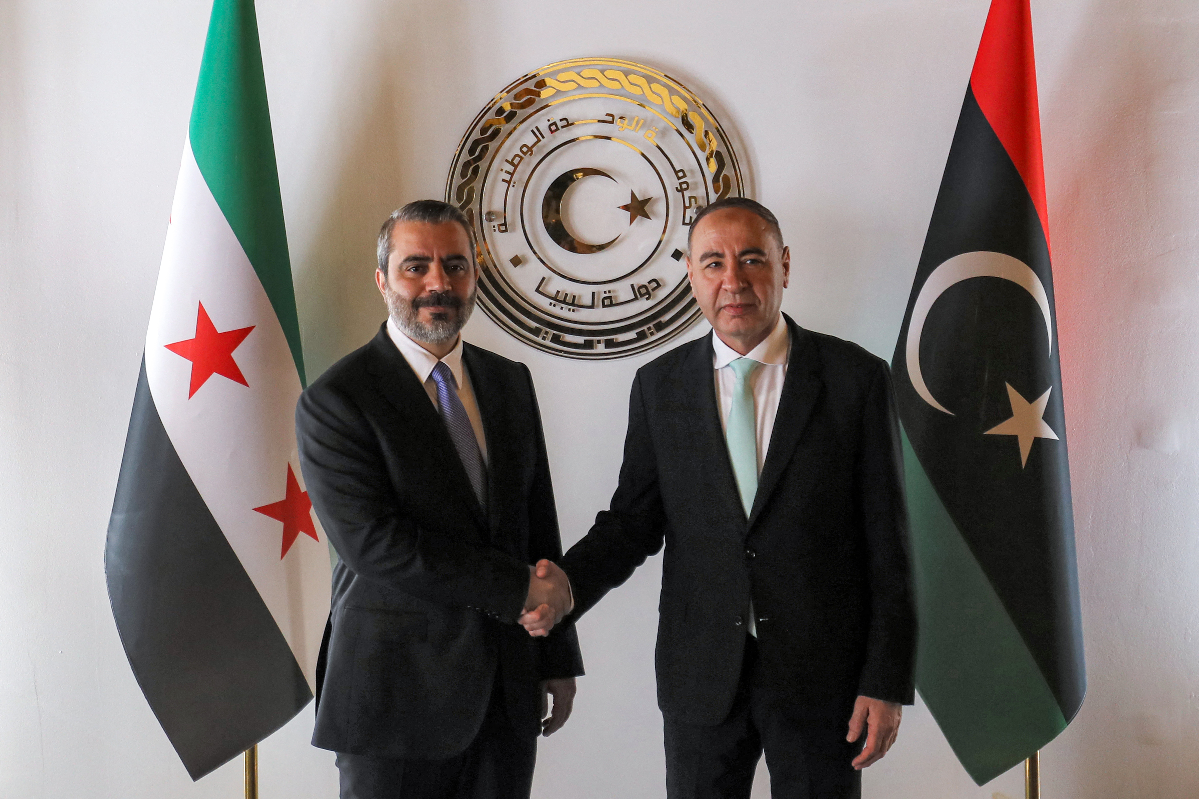 Libya's Tripoli-based Government of National Unity (GNU) Foreign Minister Taher al-Baour (R) receives Syria's interim foreign minister Asaad Shaibani (L) at the ministry headquarters in Tripoli on August 30, 2026.