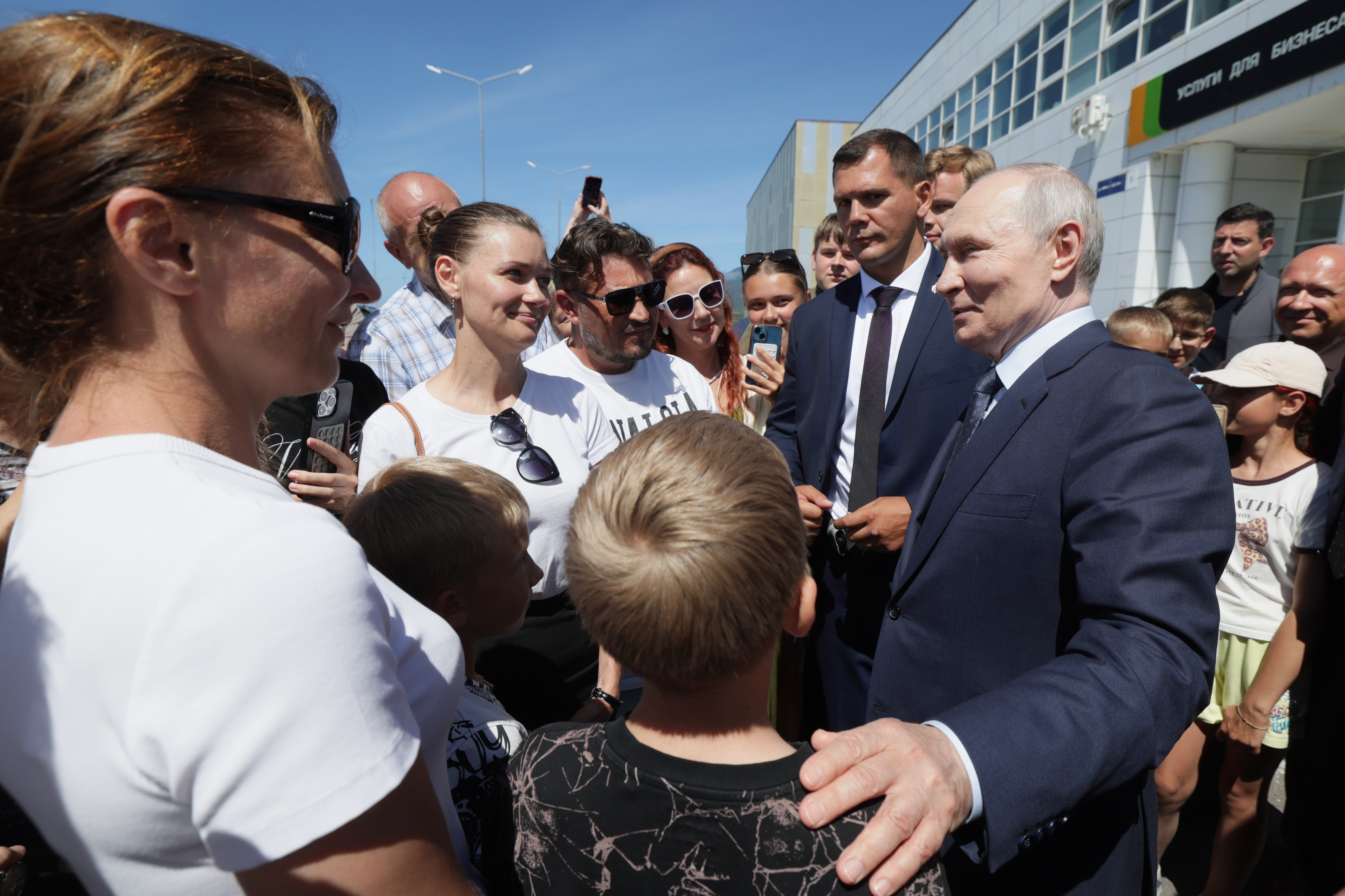 Russian President Vladimir Putin, right, interacts with local residents in Kurilsk on the Iturup Island, the largest of the Kuril Islands of Russia's far-east, Thursday, Aug. 13, 2026. (Gavriil Grigorov, Sputnik, Kremlin Pool Photo via AP)