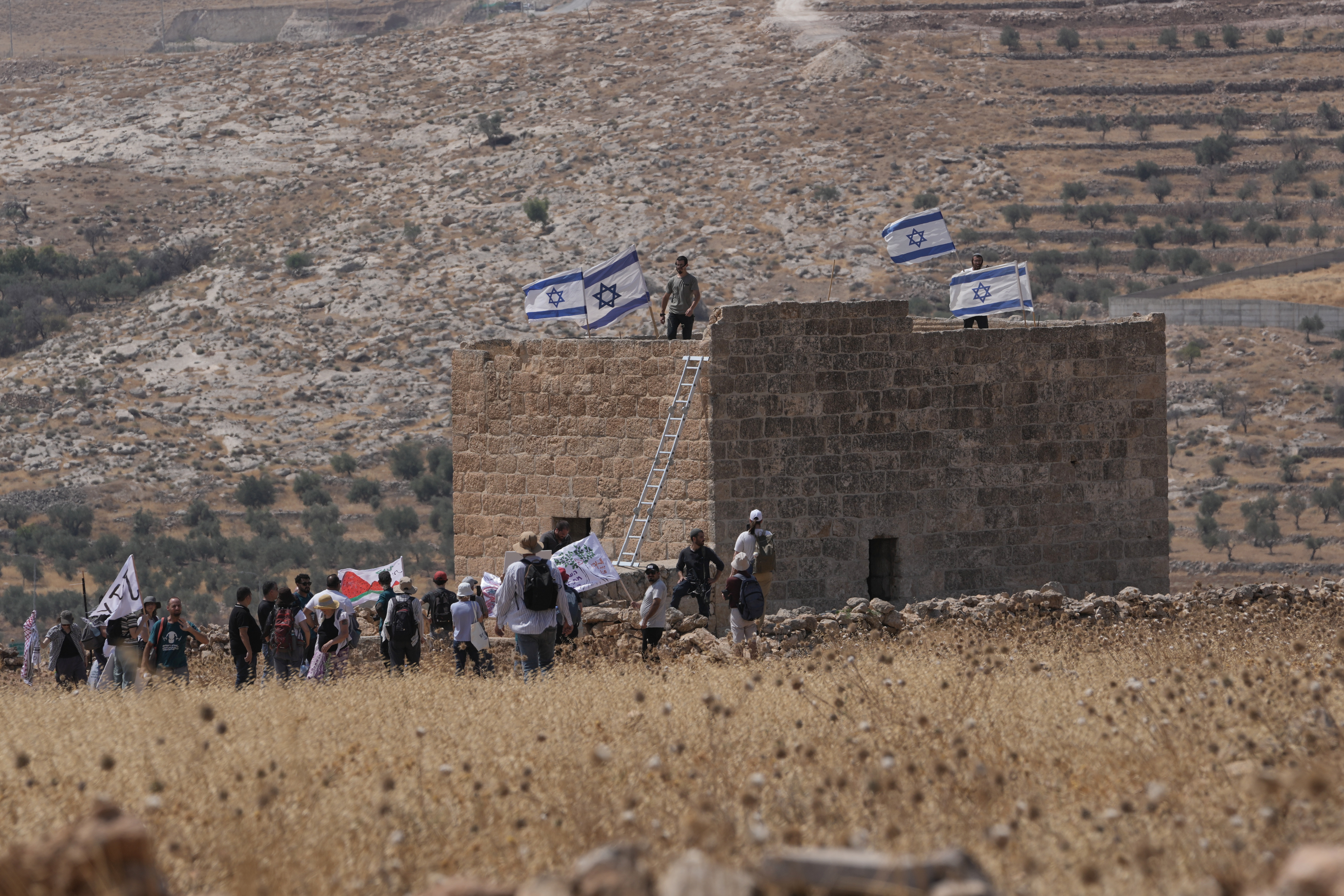 A group of people in a field around a structure