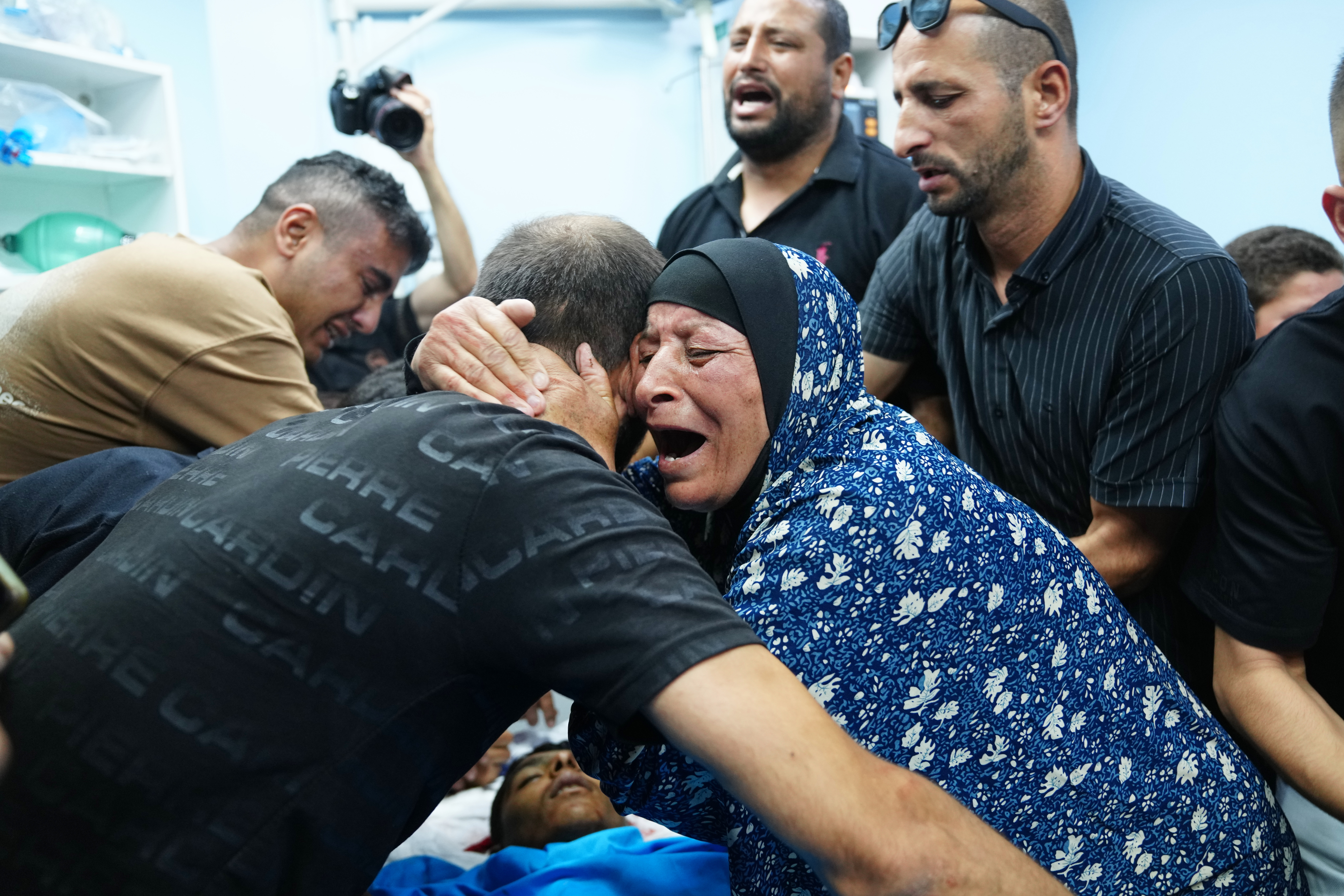 Relatives of Palestinian Karim Shalaldeh, 17, cry over his body at a hospital in the West Bank city of Hebron, Friday, Aug. 21, 2026. (AP Photo/Mahmoud Illean)