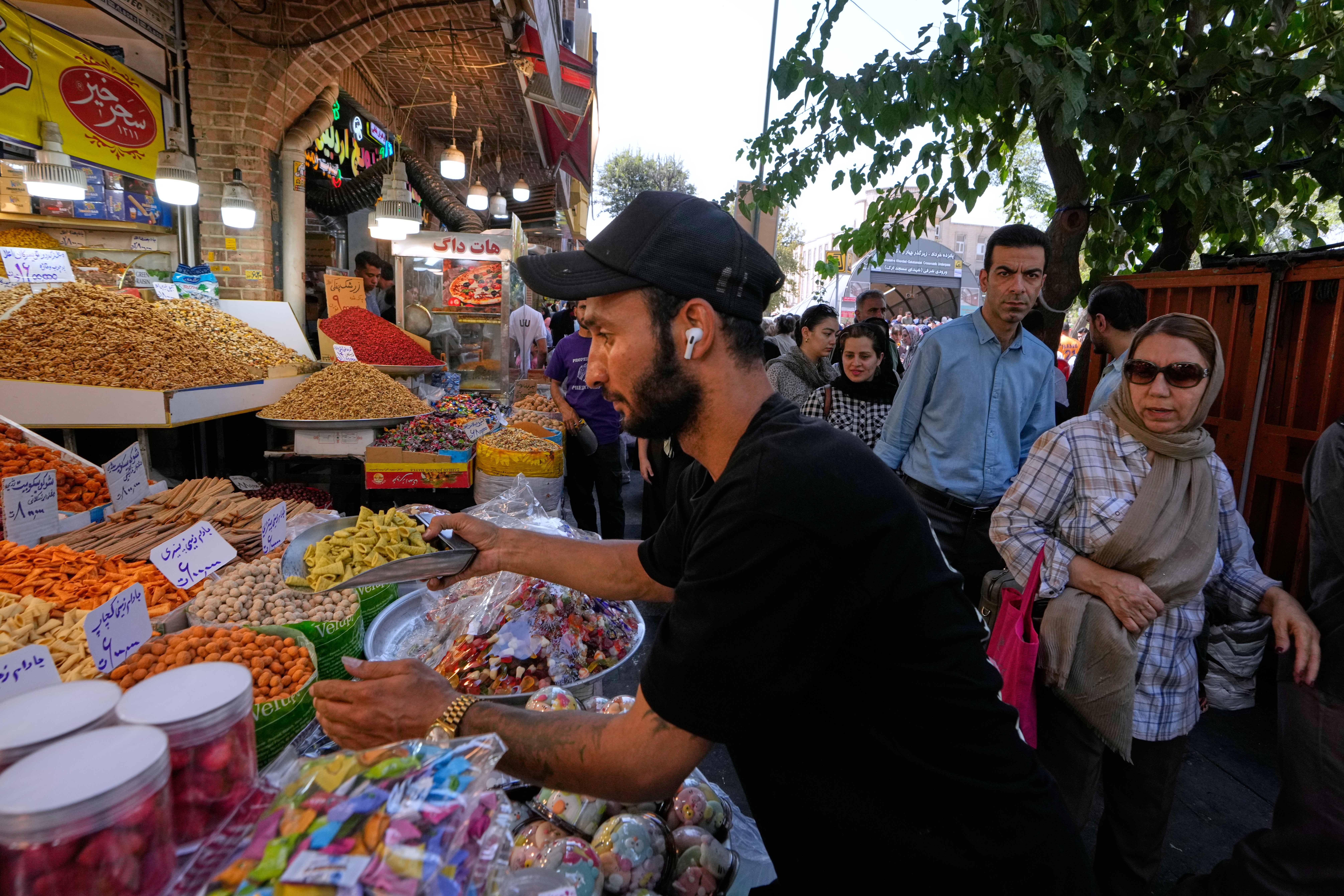 A shopkeeper arranges snacks at his shop at Tehran's Grand Bazaar in Tehran, Iran, Tuesday, Aug. 25, 2026. (AP Photo/Vahid Salemi)