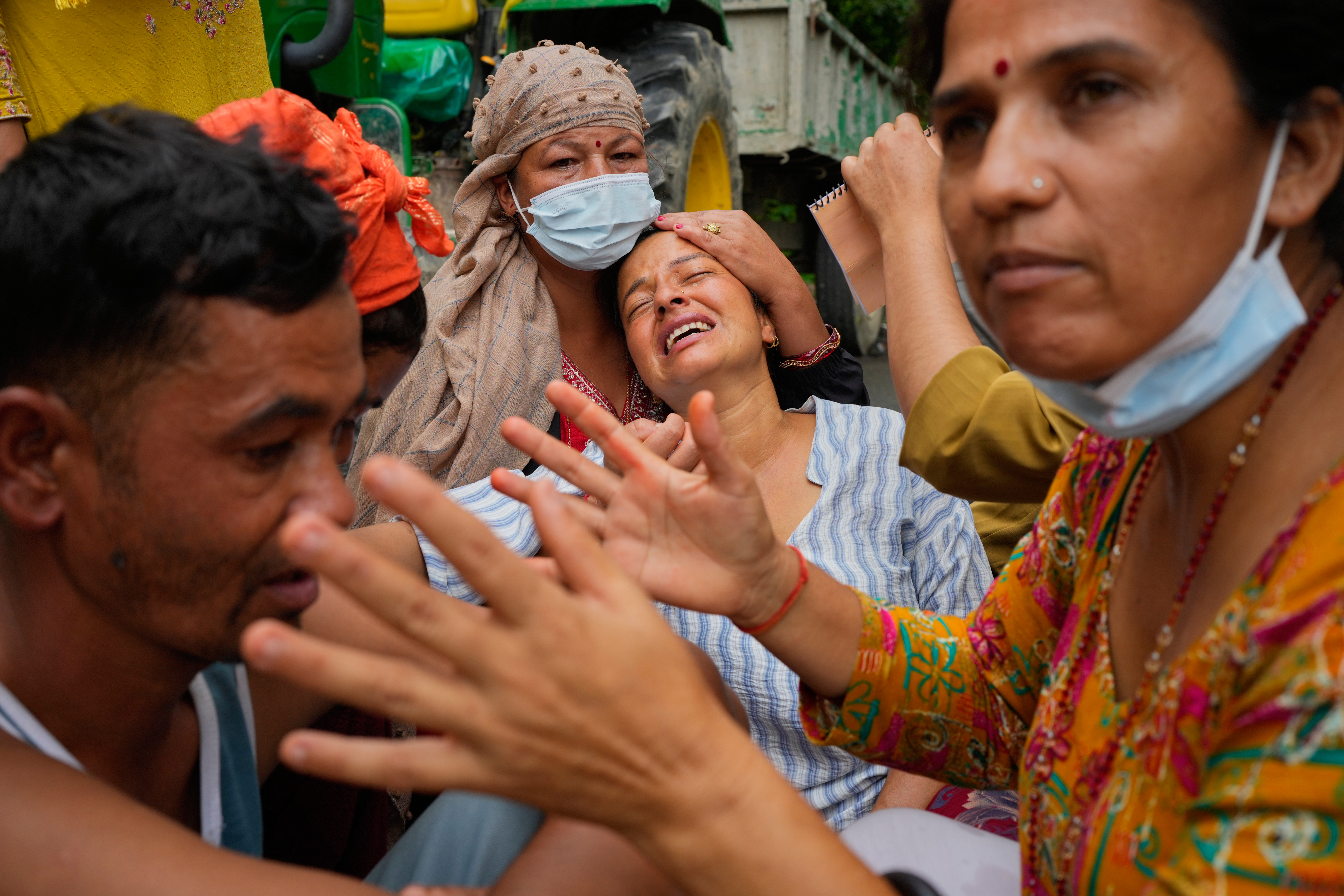 Relatives console Muna Khadka, center, who lost her son Aayush Khada, in flash floods, during mass burials in Chitwan, Nepal, Monday, Aug. 31, 2026. (AP Photo/Dar Yasin)