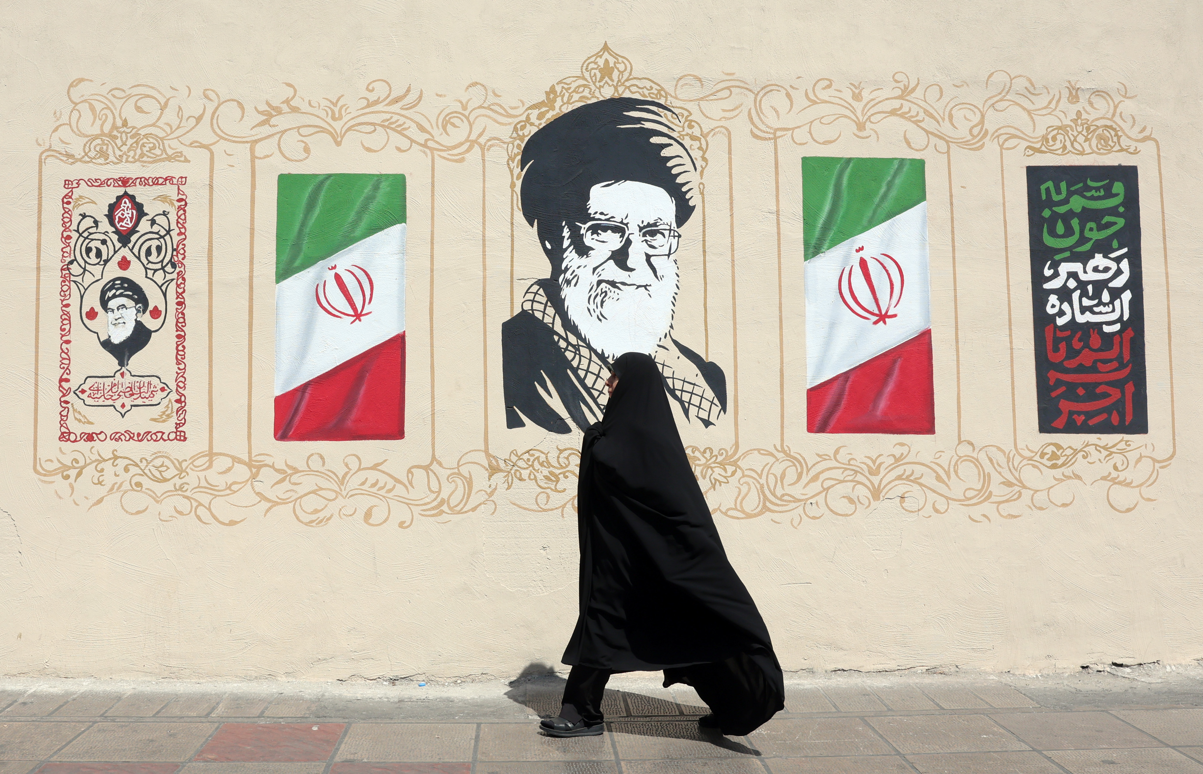 epa13178287 A woman walks next to a wall painting depicting the late Iranian supreme leader Ayatollah Ali Khamenei in Tehran, Iran, 19 August 2026. Iranian parliament speaker Mohammad Bagher Ghalibaf said that the Strait of Hormuz will remain closed until the United States lifts its blockade and ends sanctions. EPA/ABEDIN TAHERKENAREH RESTRICTIONS: NO Access Israel Media/Persian Language TV Stations Outside Iran/Strictly No Access BBC Persian/VOA Persian/Manoto TV/Iran International TV. (As mandated by Iran's Directorate General for Foreign Media) --