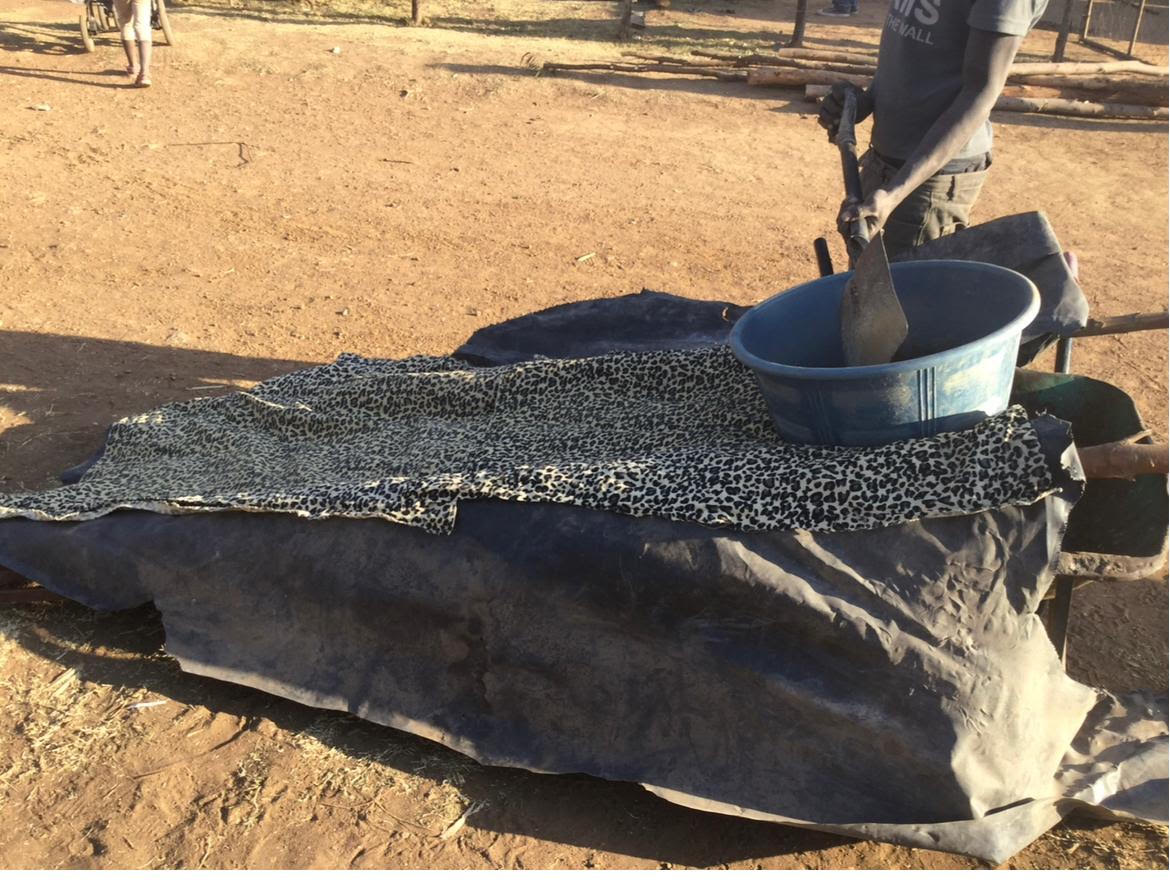 Illegal chrome processors handle ore at a site near Rustenburg in South Africa’s North West province [Tsitsi Bhobo/Al Jazeera]