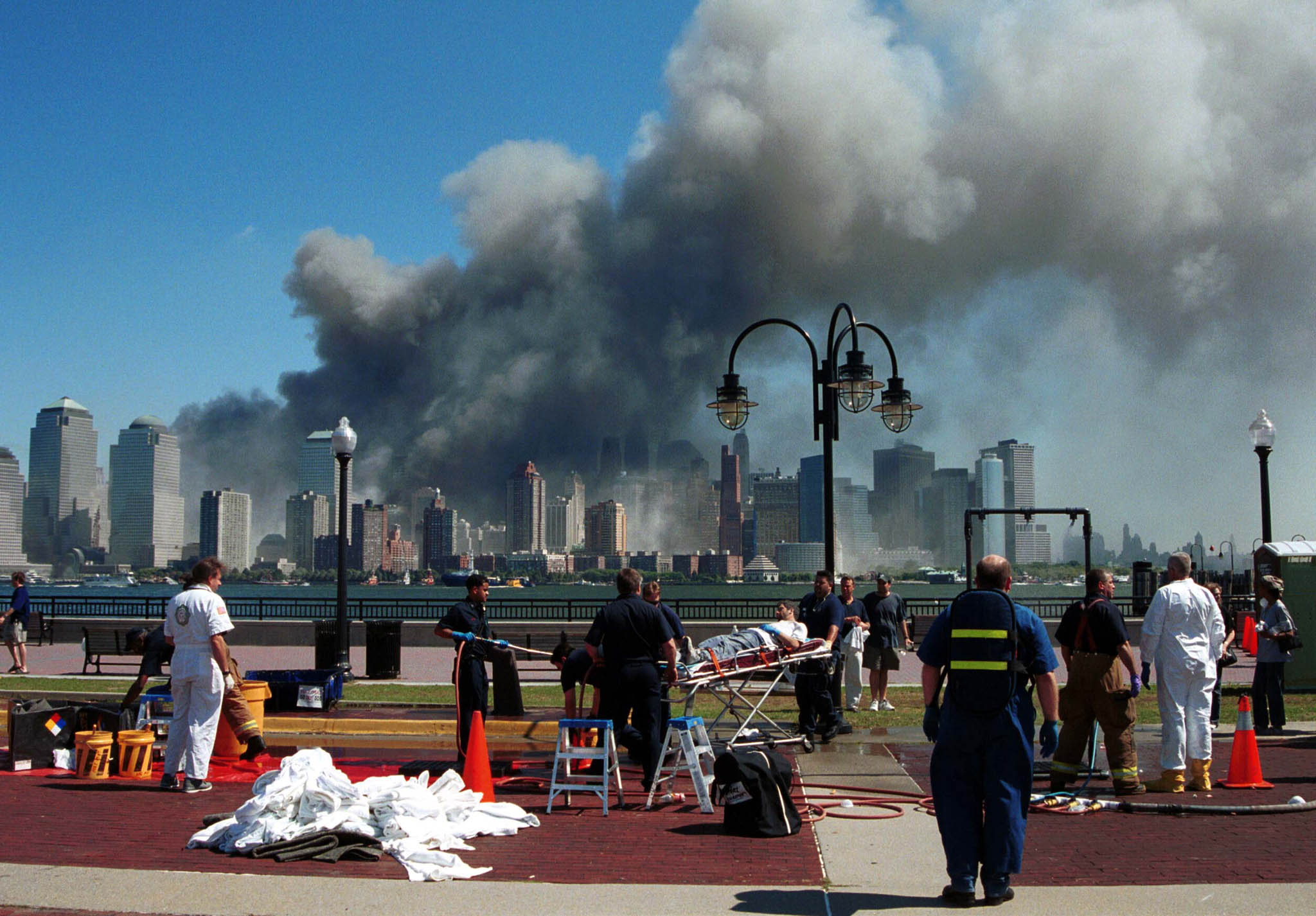 Emergency personnel tend to injured people in Liberty State Park, in Jersey City, New Jersey, after two hijacked planes slammed into the twin towers of New York’s World Trade Center on September 11, 2001, causing both 110-storey landmarks to collapse in lower Manhattan, across the Hudson River