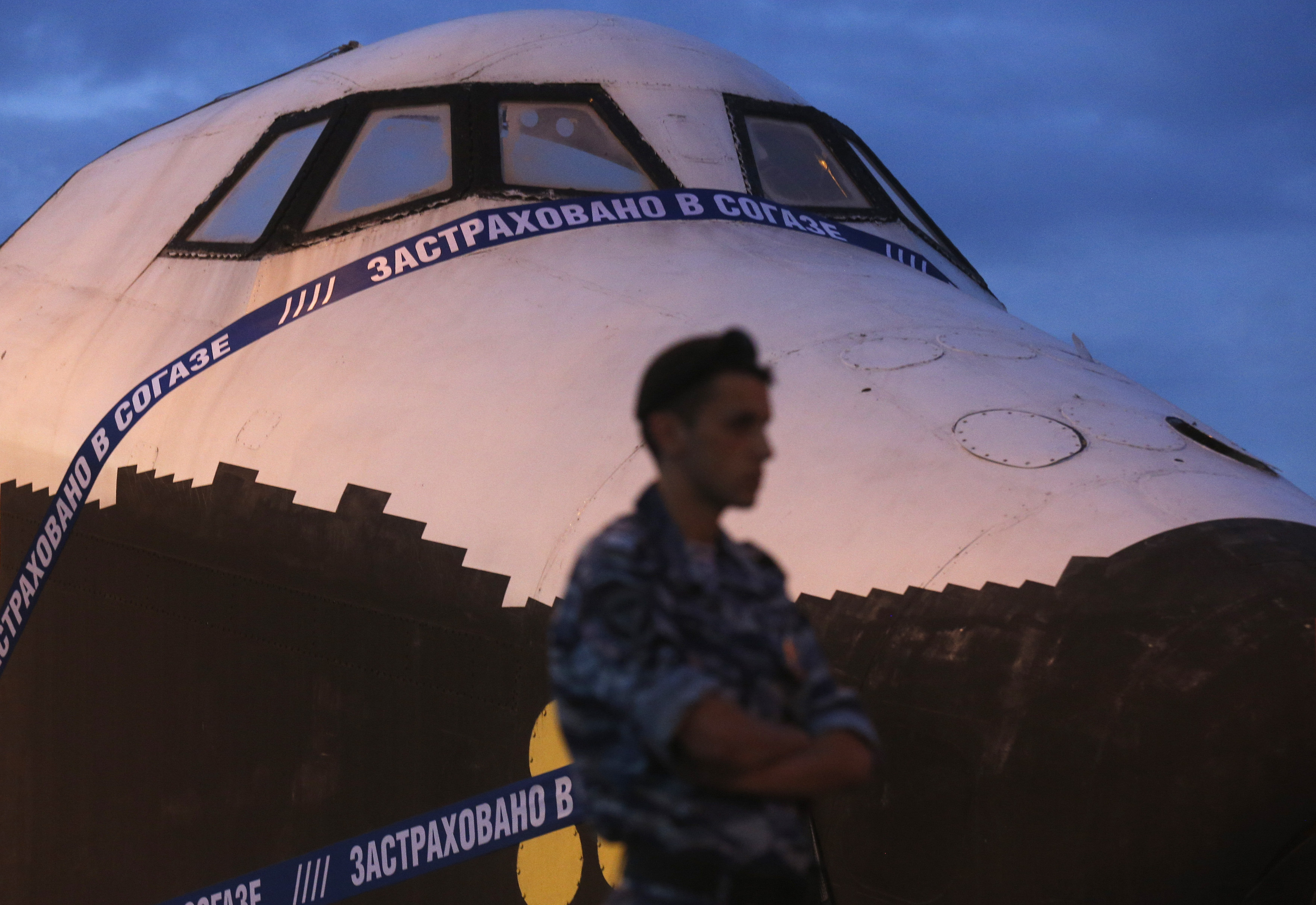 A police officer stands guard in front of a life-sized model of Soviet-made Buran space orbiter
