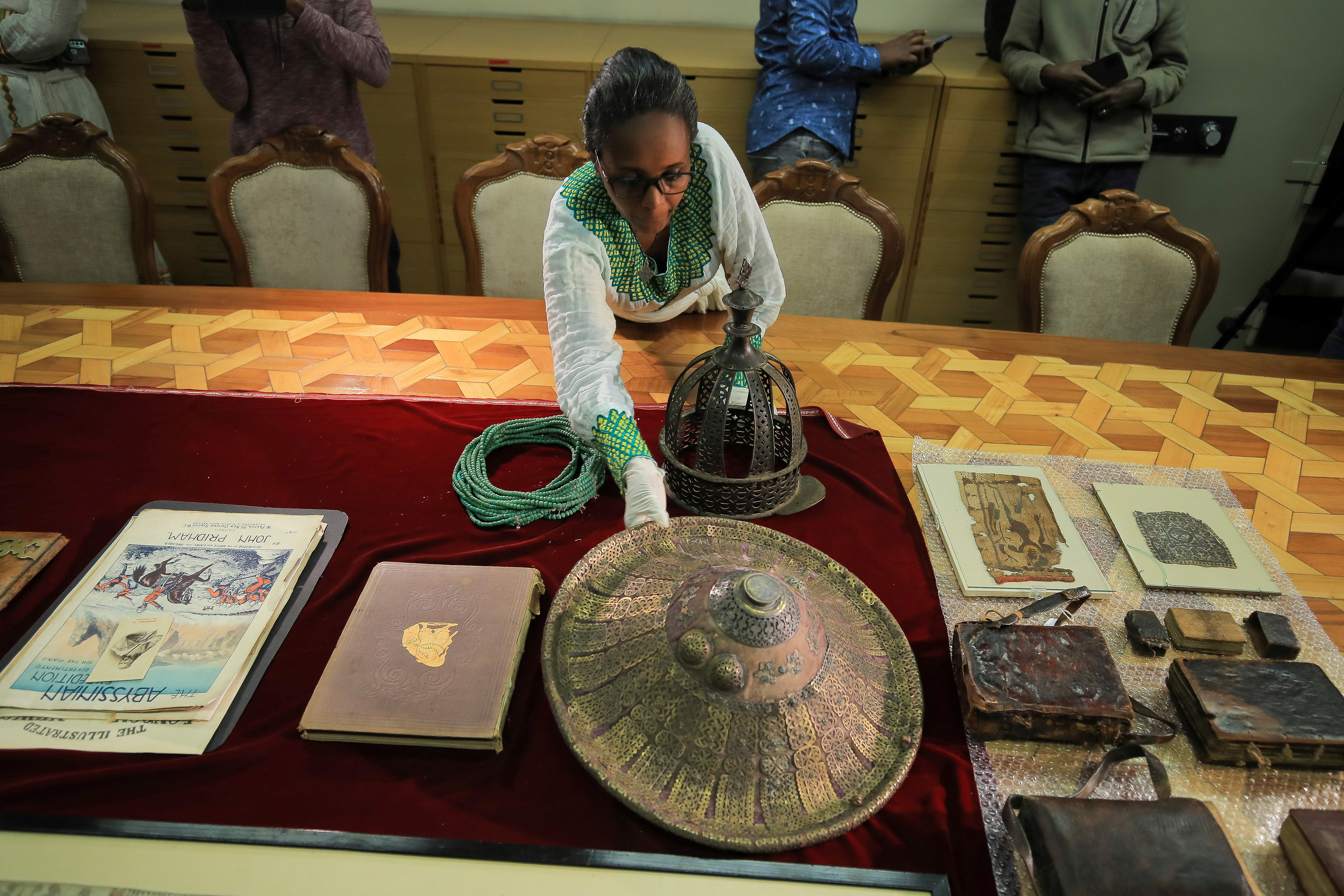 An employee arranges artefacts that were looted during the colonial-era by British forces at the Ethiopian National Museum in Addis Ababa after they were restituted from the UK, November 20, 2021