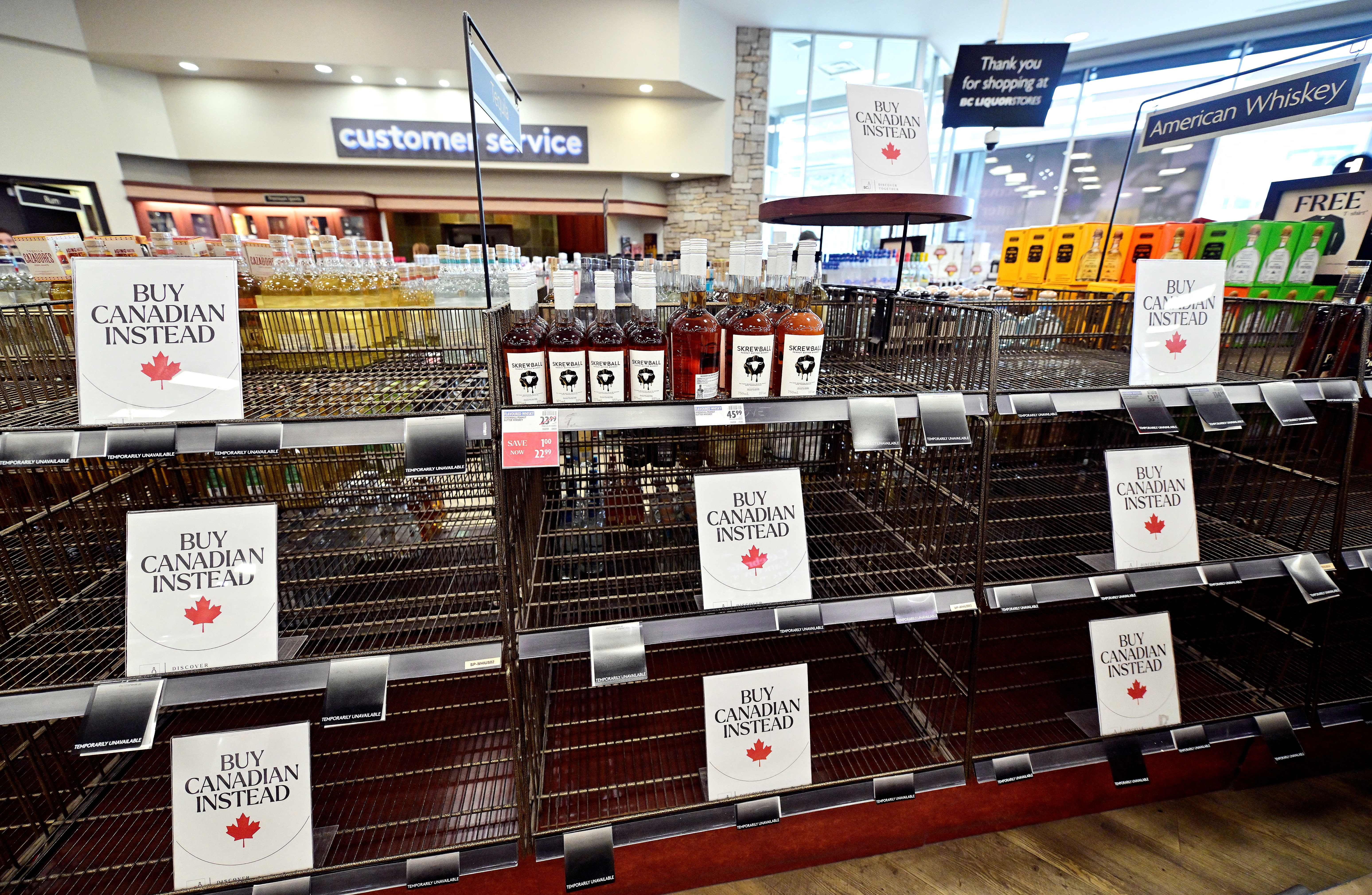 Empty shelves with Buy Canadian Instead signs are seen in the American Whiskey section of the BC Liquor in Vancouver, British Columbia, Canada March 10, 2025 [Jennifer Gauthier/Reuters]