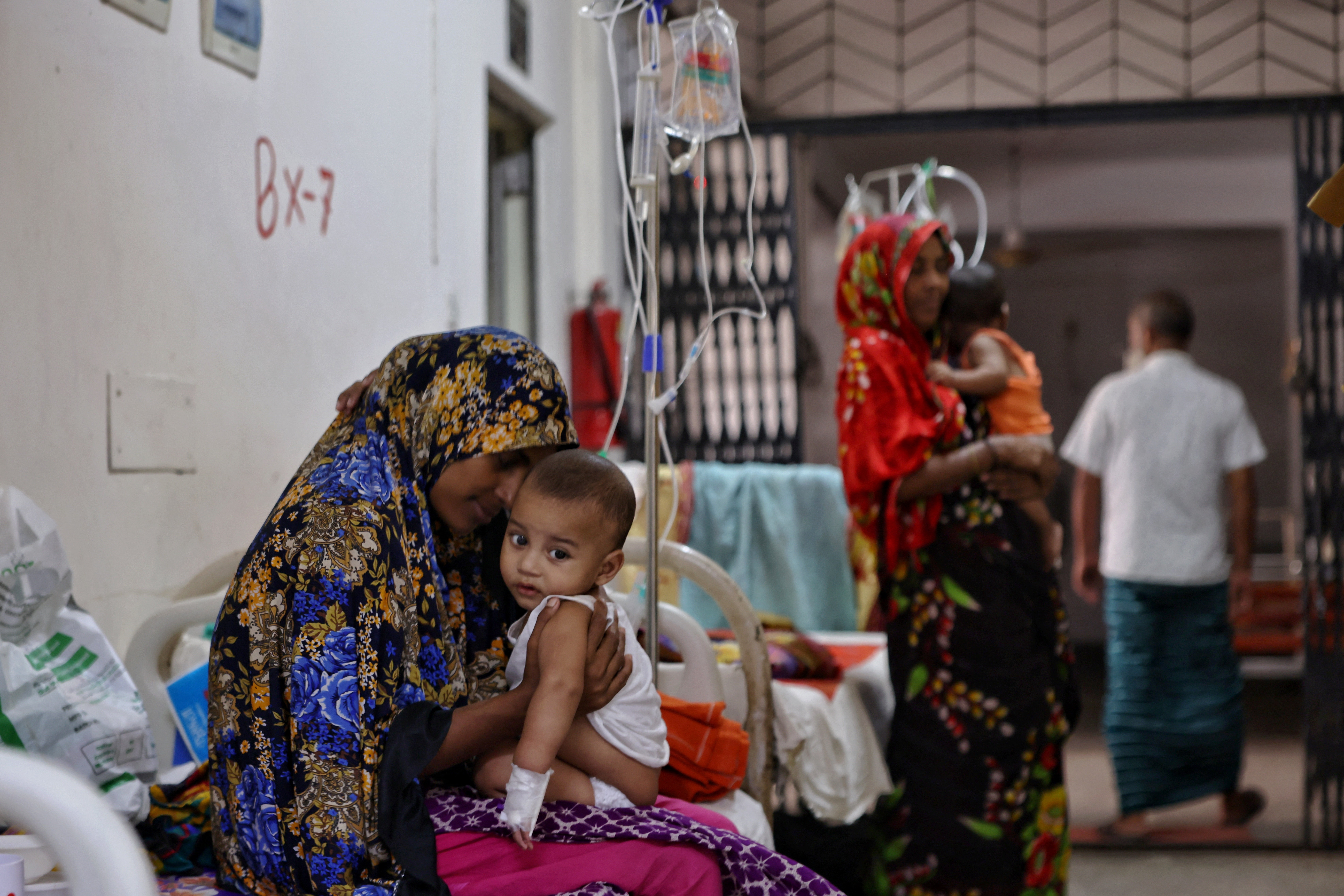 Mariam, 22, cuddles her nine-months-old son Nayem, who suffers from measles and receives treatment at the Infectious Diseases Hospital in Dhaka, Bangladesh, September 9, 2026. [Mohammad Ponir Hossain/Reuters]