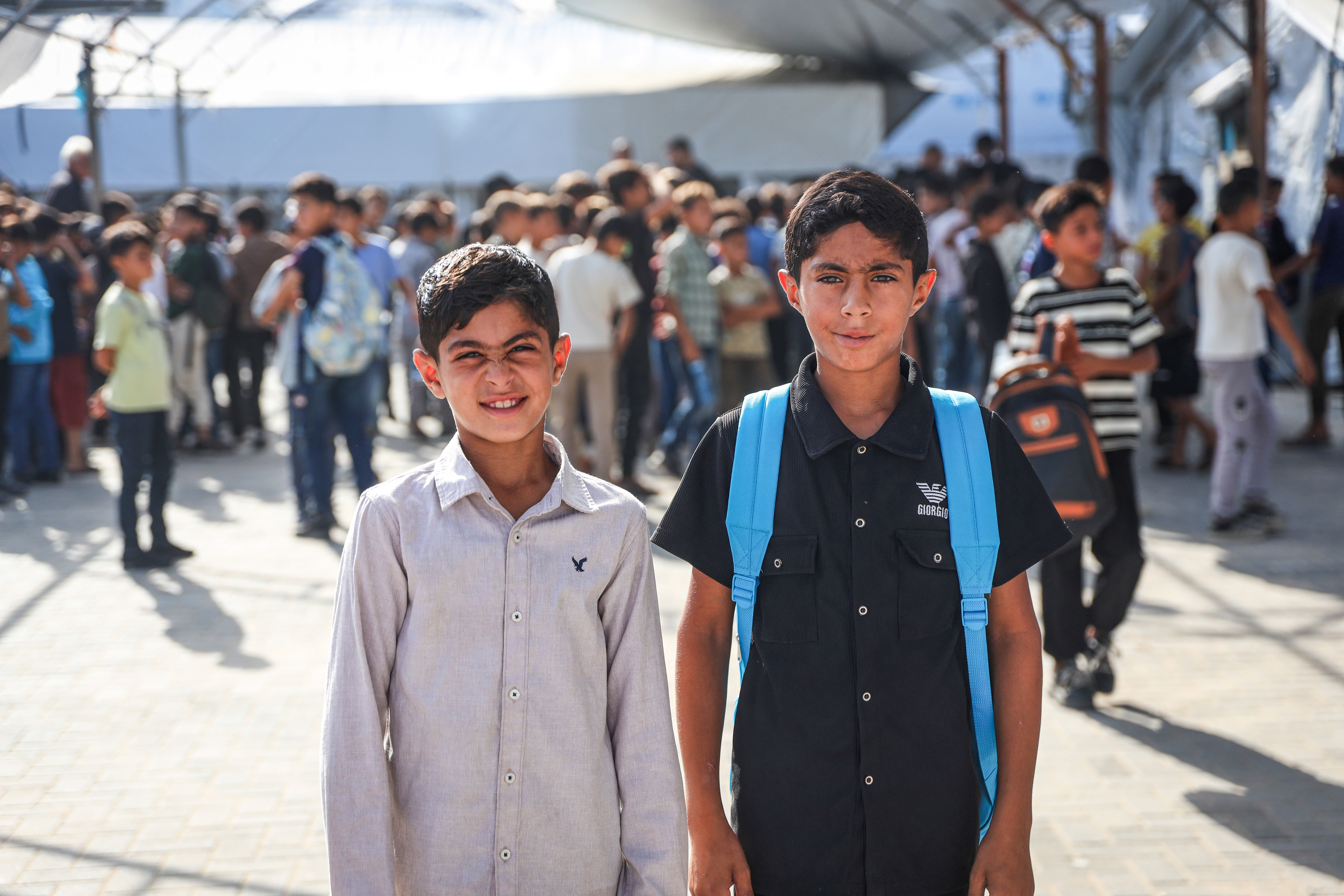 Jihad, 11, right, and Ibrahim, 10, left, return to school after two years of disrupted education due to displacement [Abdelhakim Abu Riash/Al Jazeera]