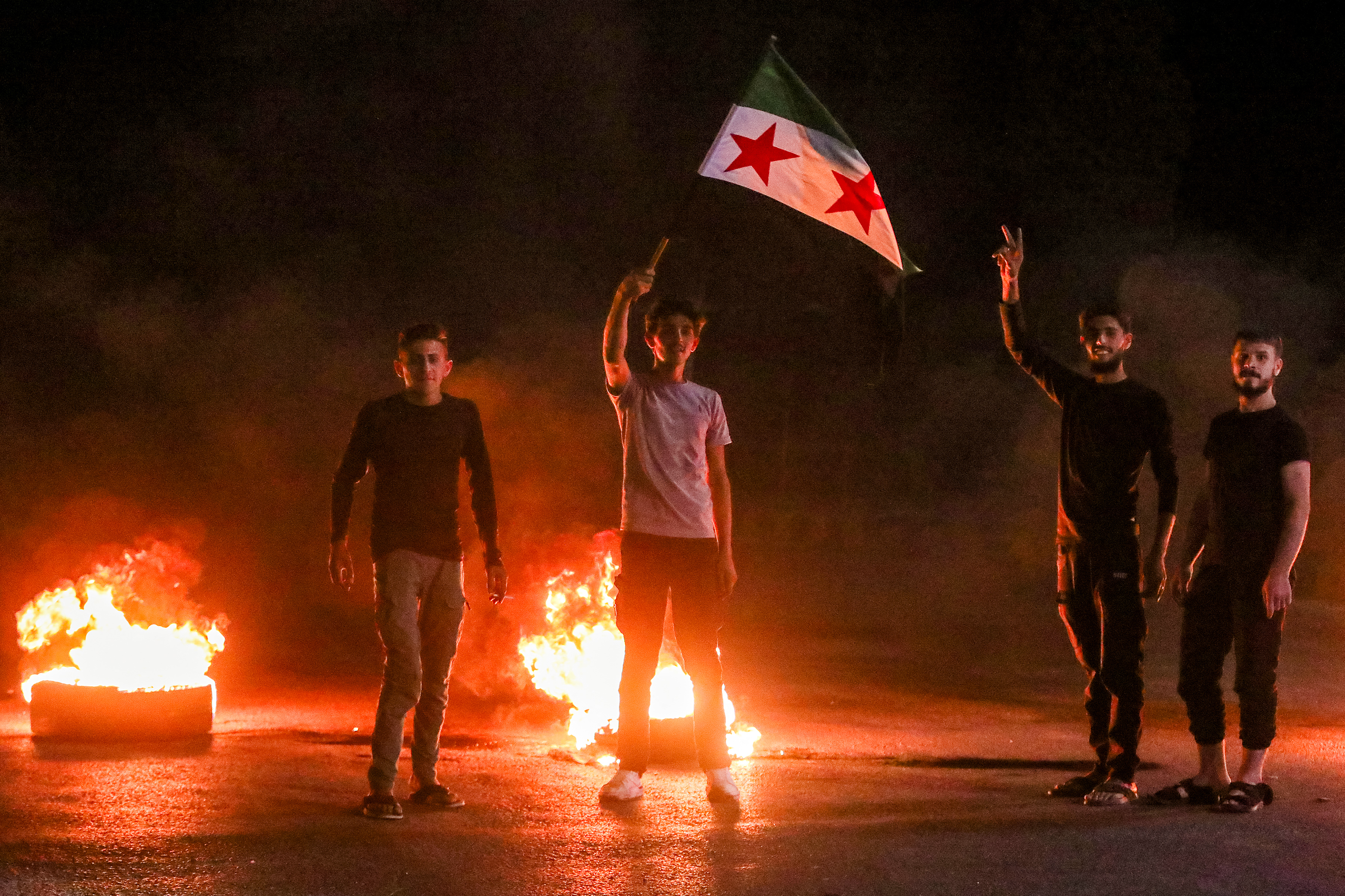 Demonstrators block a road with flaming tires
