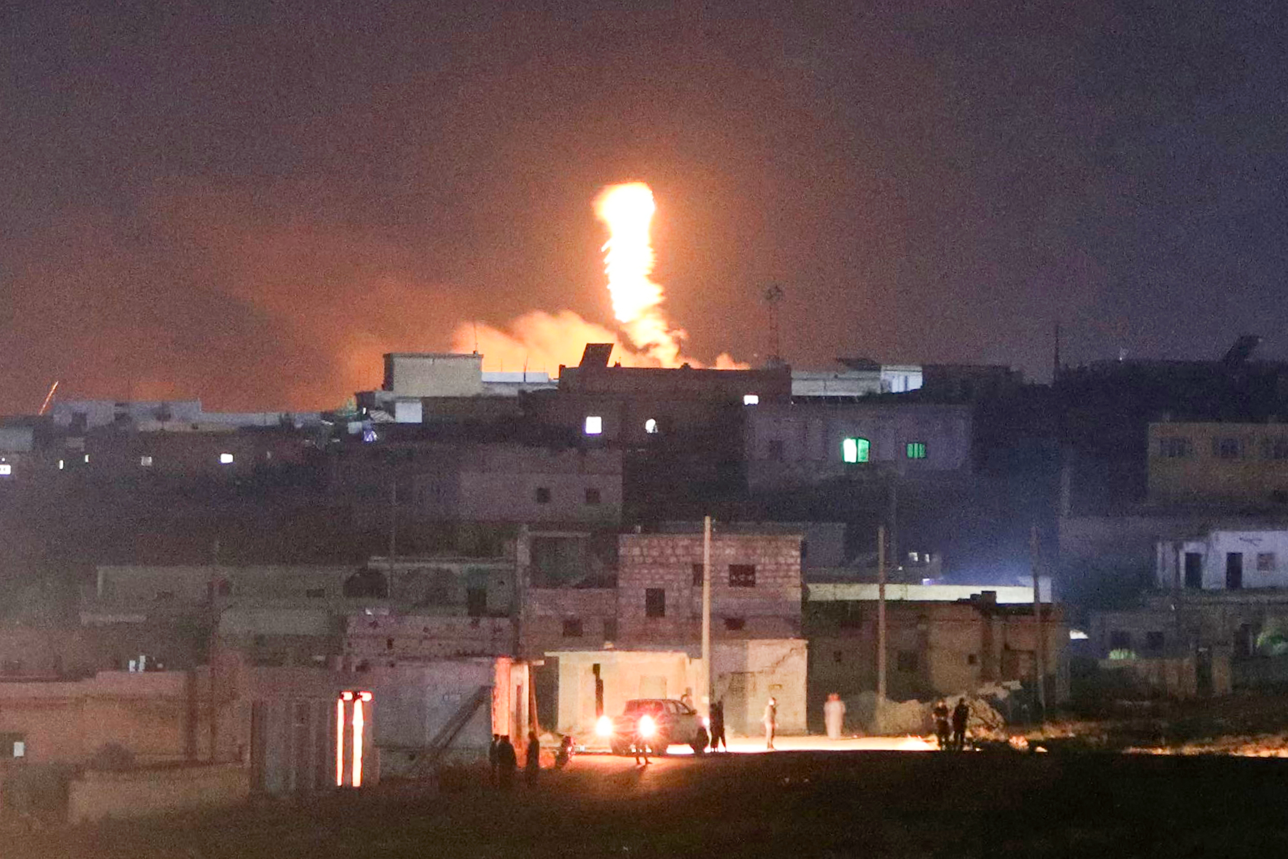 A fireball rises following an explosion at a Syrian army site in the vicinity of Al-Eis town early on September 21, 2026. At least four people were injured following a series of explosions at an Aleppo army site in northern Syria, state media reported. The cause of the explosions was not immediately known. (Photo by Abdulaziz KETAZ / AFP)