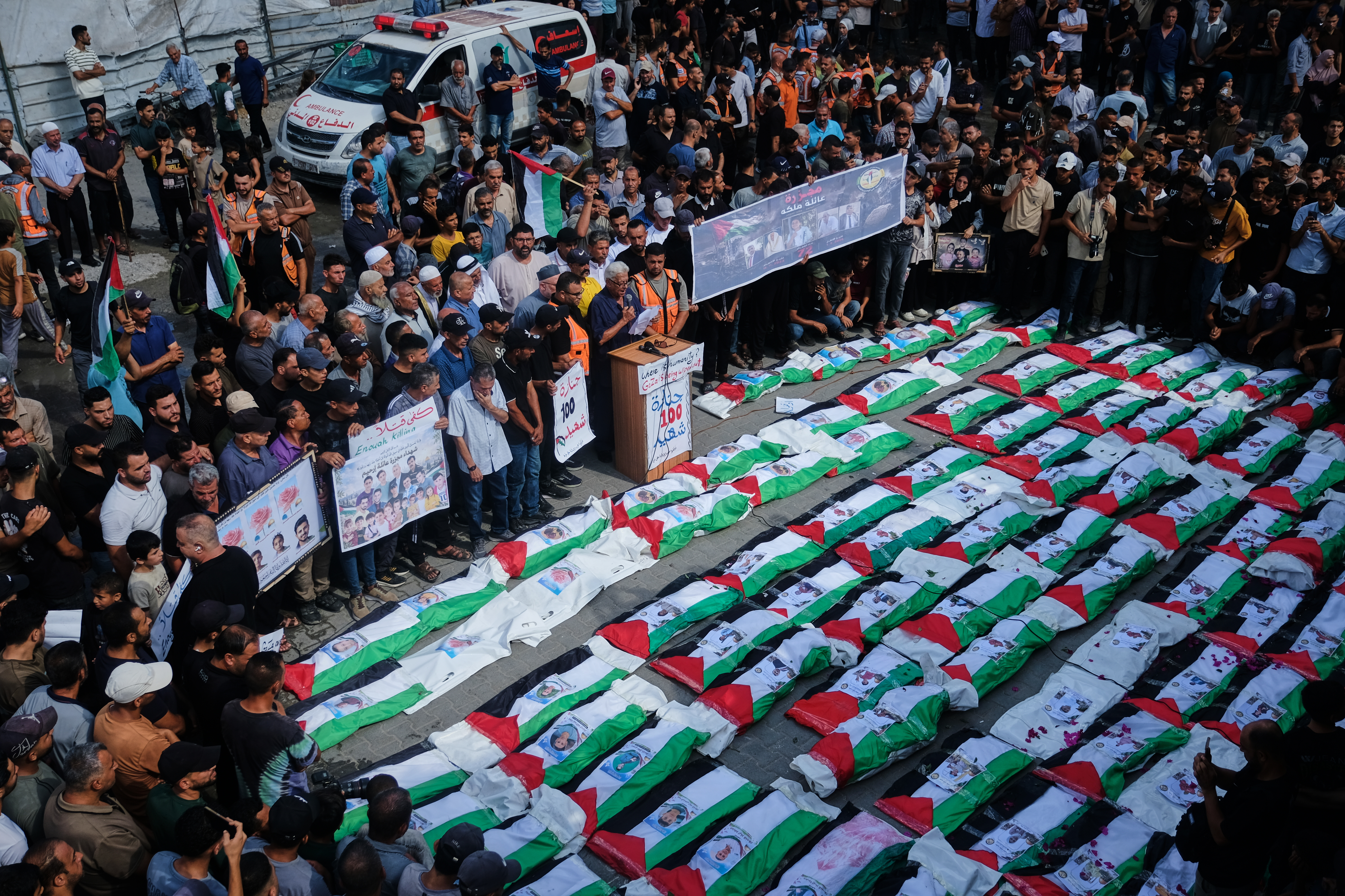 Mourners gather around the flag-draped bodies of Palestinians killed in Israeli strikes during the war with Hamas, whose remains were recently recovered from the rubble, in Gaza City