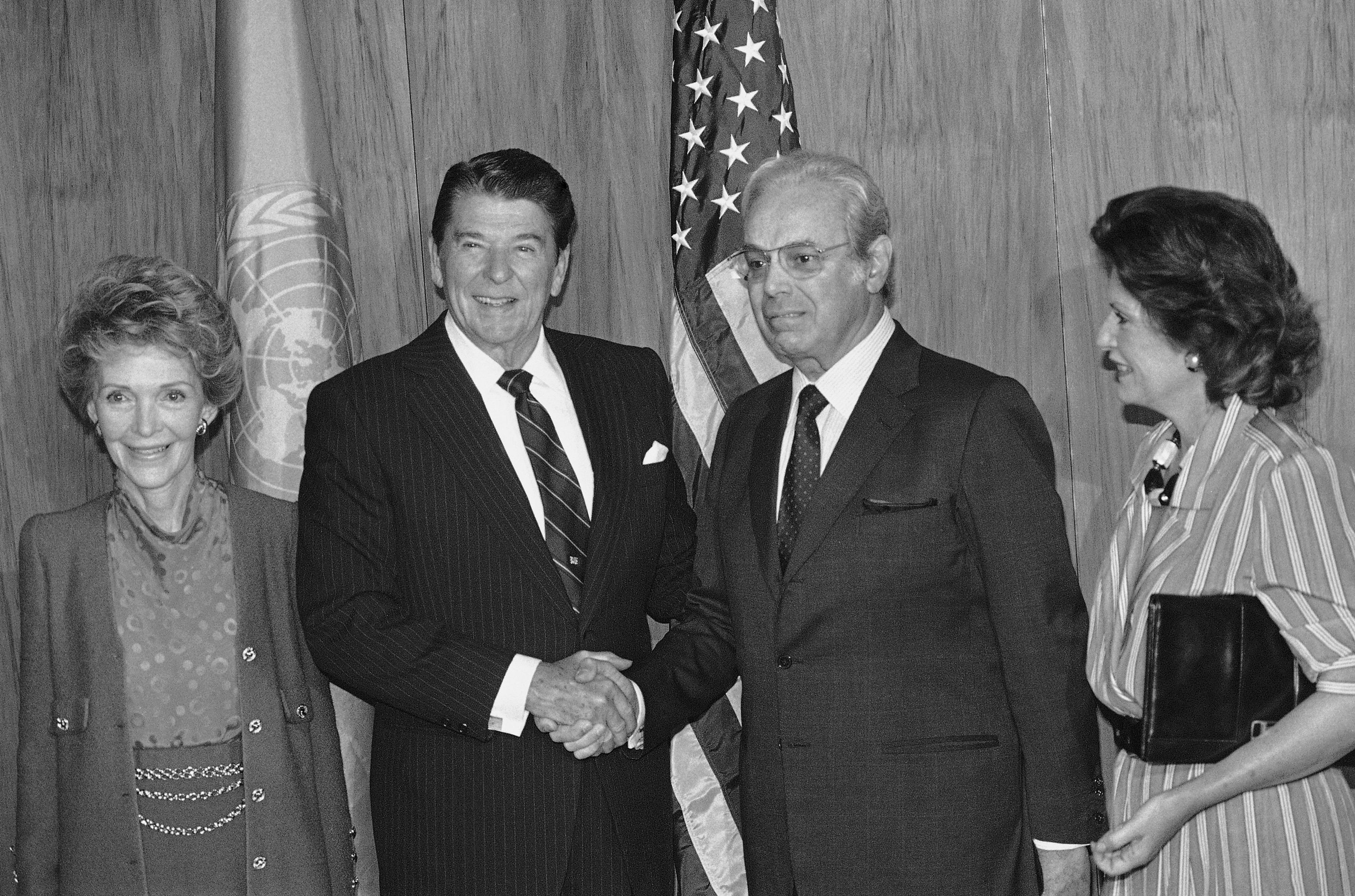 United Nations Secretary General Javier Perez de Cuellar shakes hands with President Ronald Reagan as first Lady Nancy Ragan, left, and Marcela look on as they arrive at the United Nations, Monday, Sept. 24, 1984. (APP Photo/G. Paul Burnett)