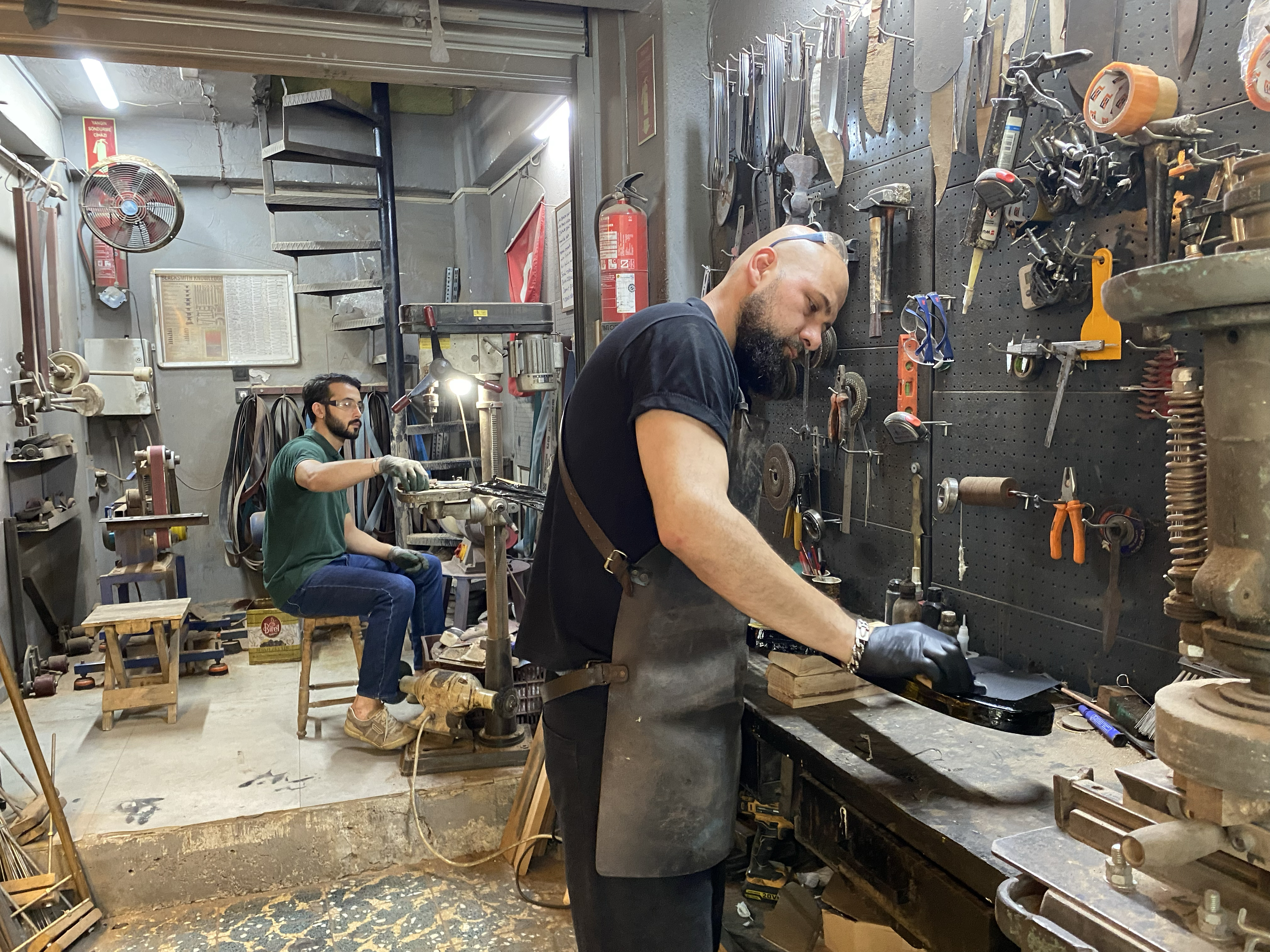 Yagiz Can Sonmez, left, works alongside Suleyman Akdemir at the family forge