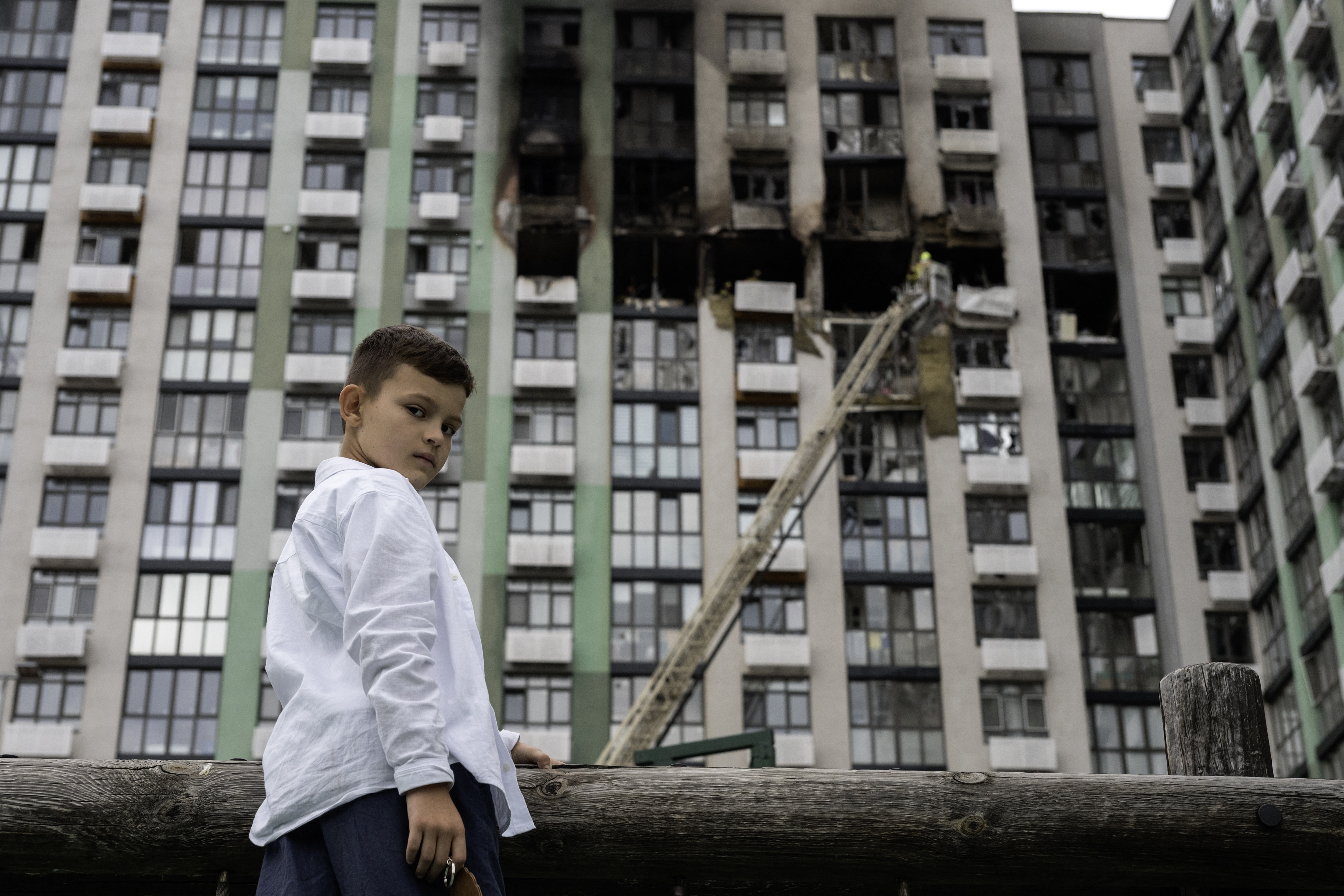 A boy stands near the site of a heavily damaged residential building following a Russian strike in Kyiv on September 1, 2026, amid the Russian invasion of Ukraine.