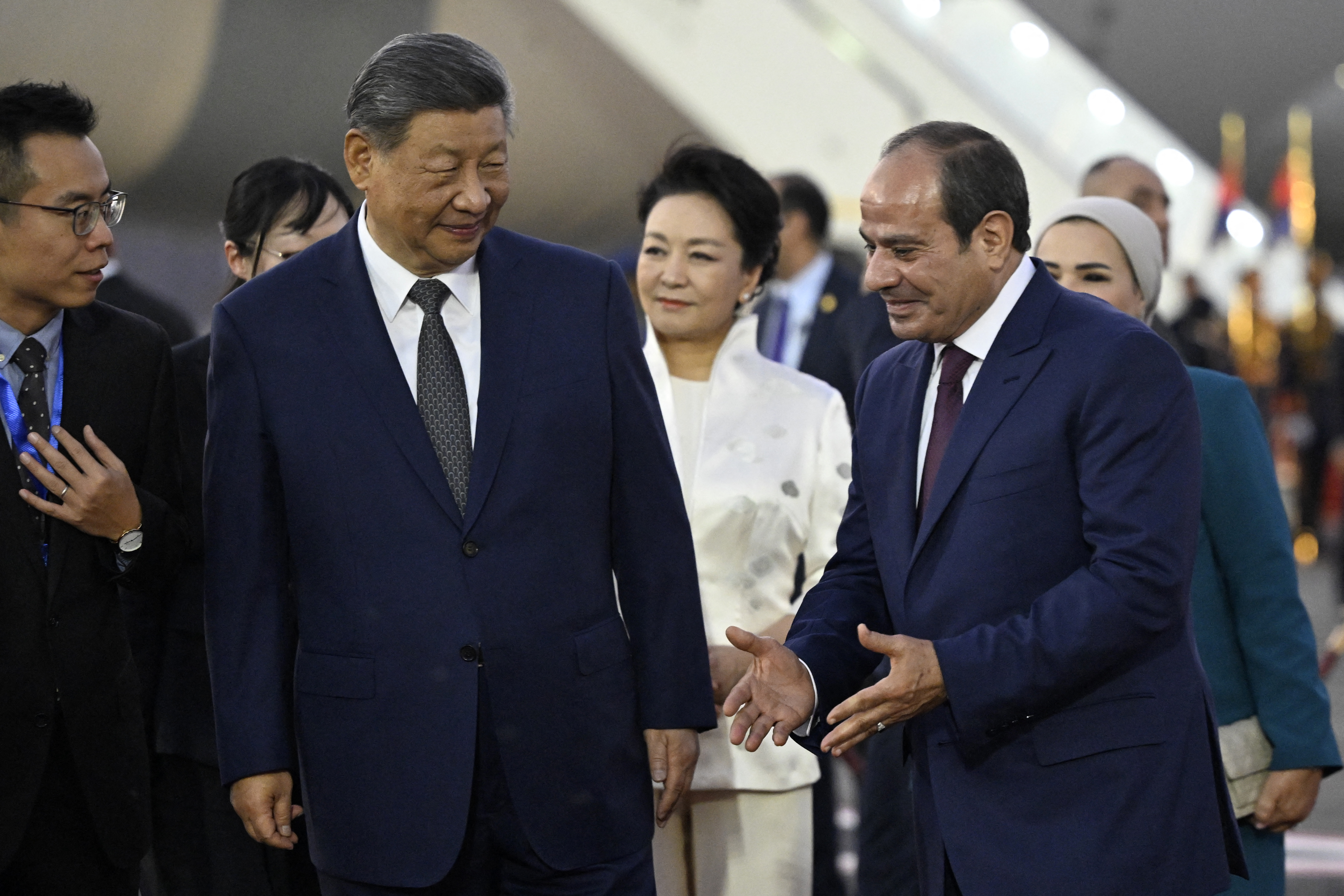 China's President Xi Jinping (2L) listens to his Egyptian counterpart Abdel Fattah al-Sisi (R) as Xi's wife Peng Liyuan (C) watches upon their arrival at the Cairo International Airport on September 1, 2026.