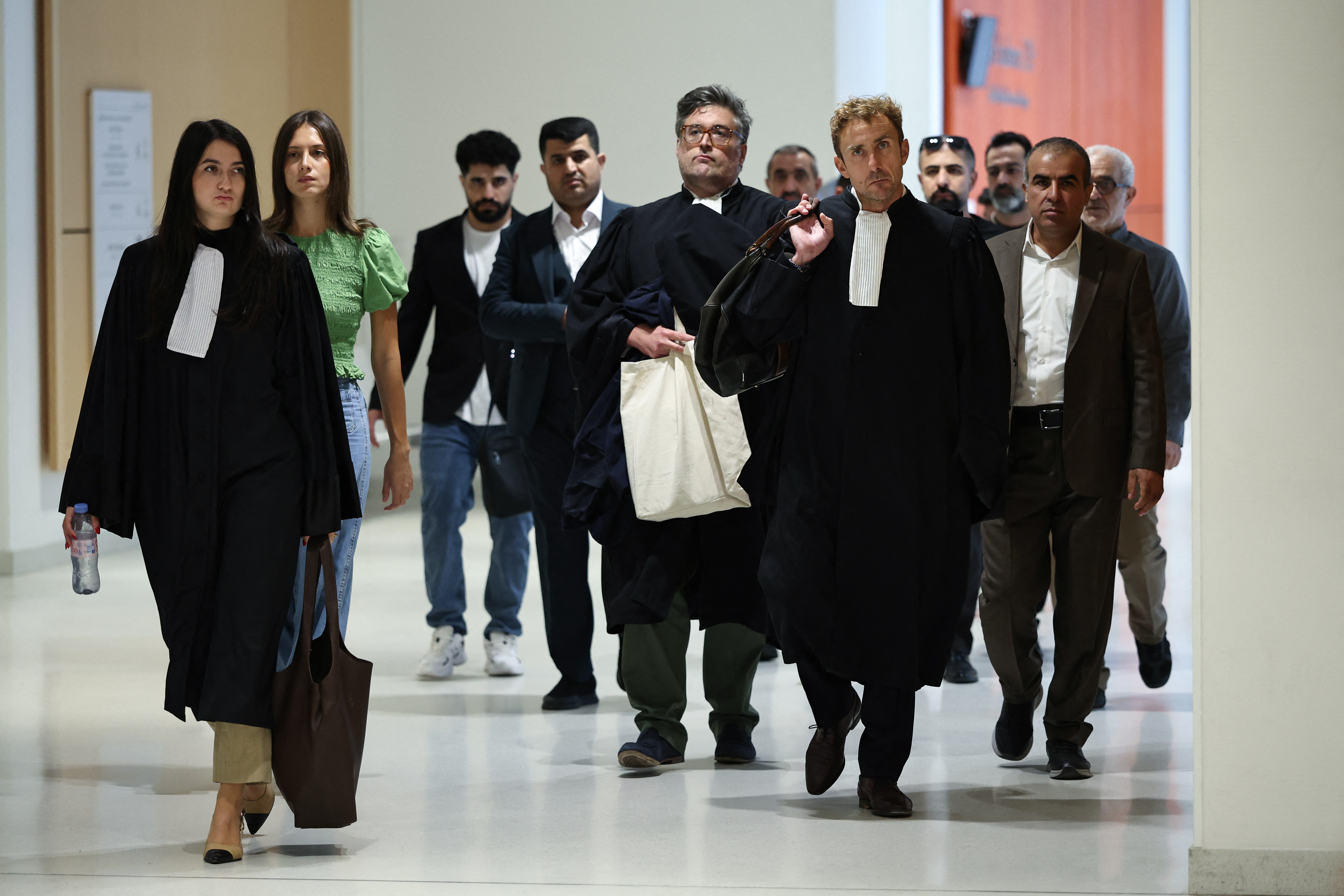 French lawyer Matthieu Chirez (front 2L) arrives with relatives of victims for the trial of the 14 alleged smugglers over the deaths of 31 migrants in the English Channel in 2021 at the Judicial court in Paris, on September 8, 2026. [AFP]