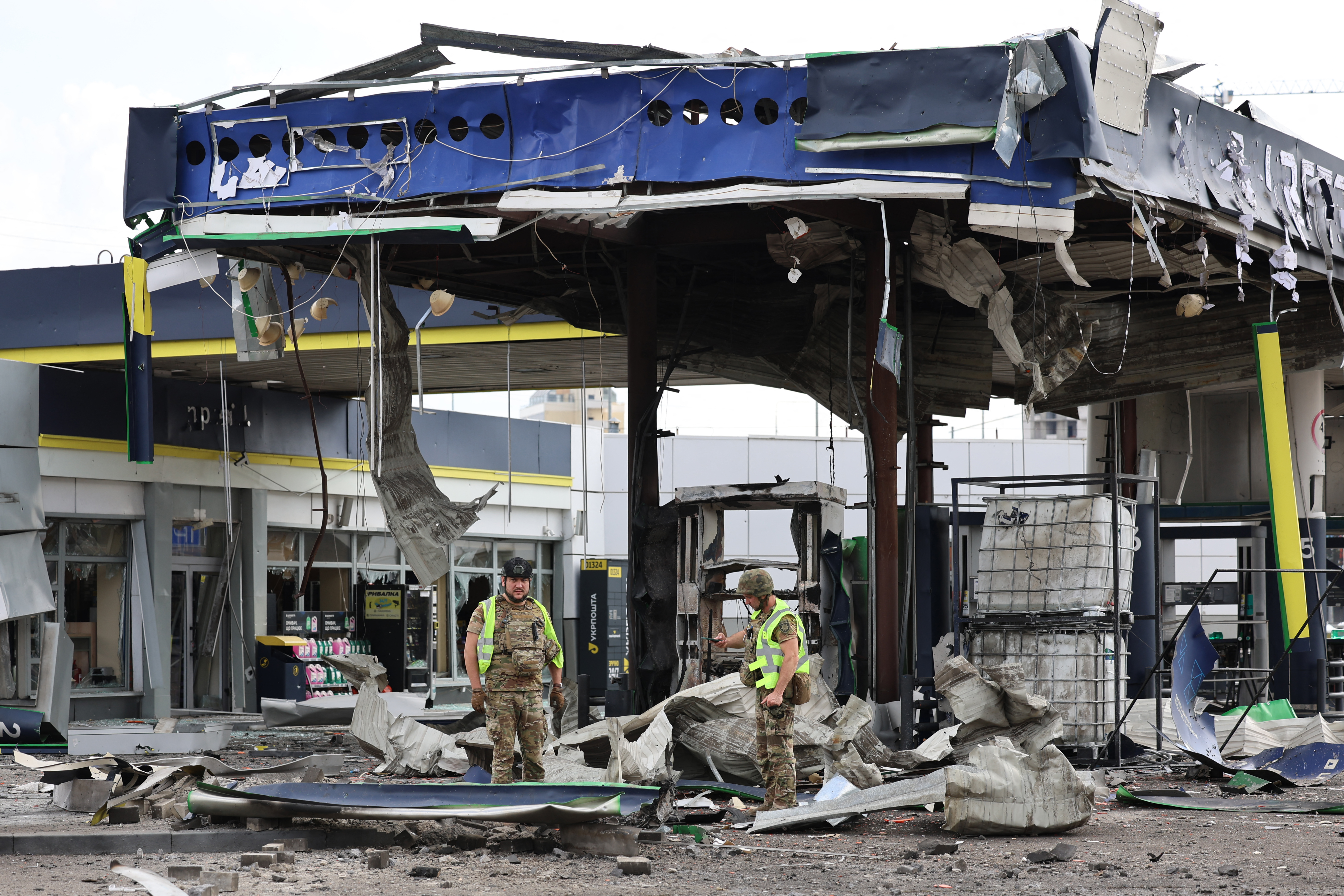 Ukrainian law enforcement officers stand among the debris of a destroyed petrol station following an air attack in Kyiv on September 11, 2026, amid the Russian invasion of Ukraine.