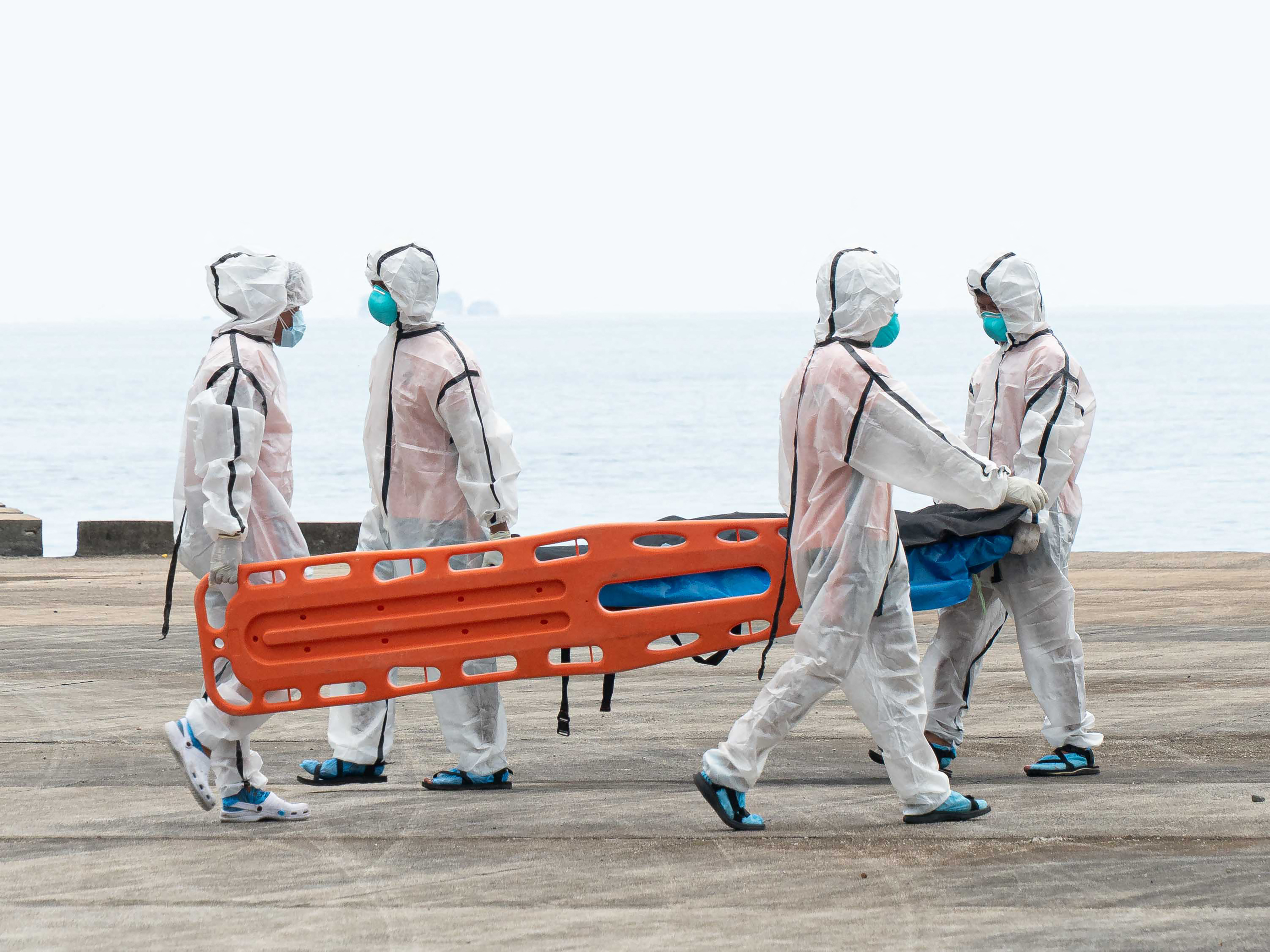 Philippine coast Guard personnel in protective suit carry a body bag of a victim from the ferry fire blaze to a tent for identification at the port of Borac in Coron, Palawan province on September 12, 2026.