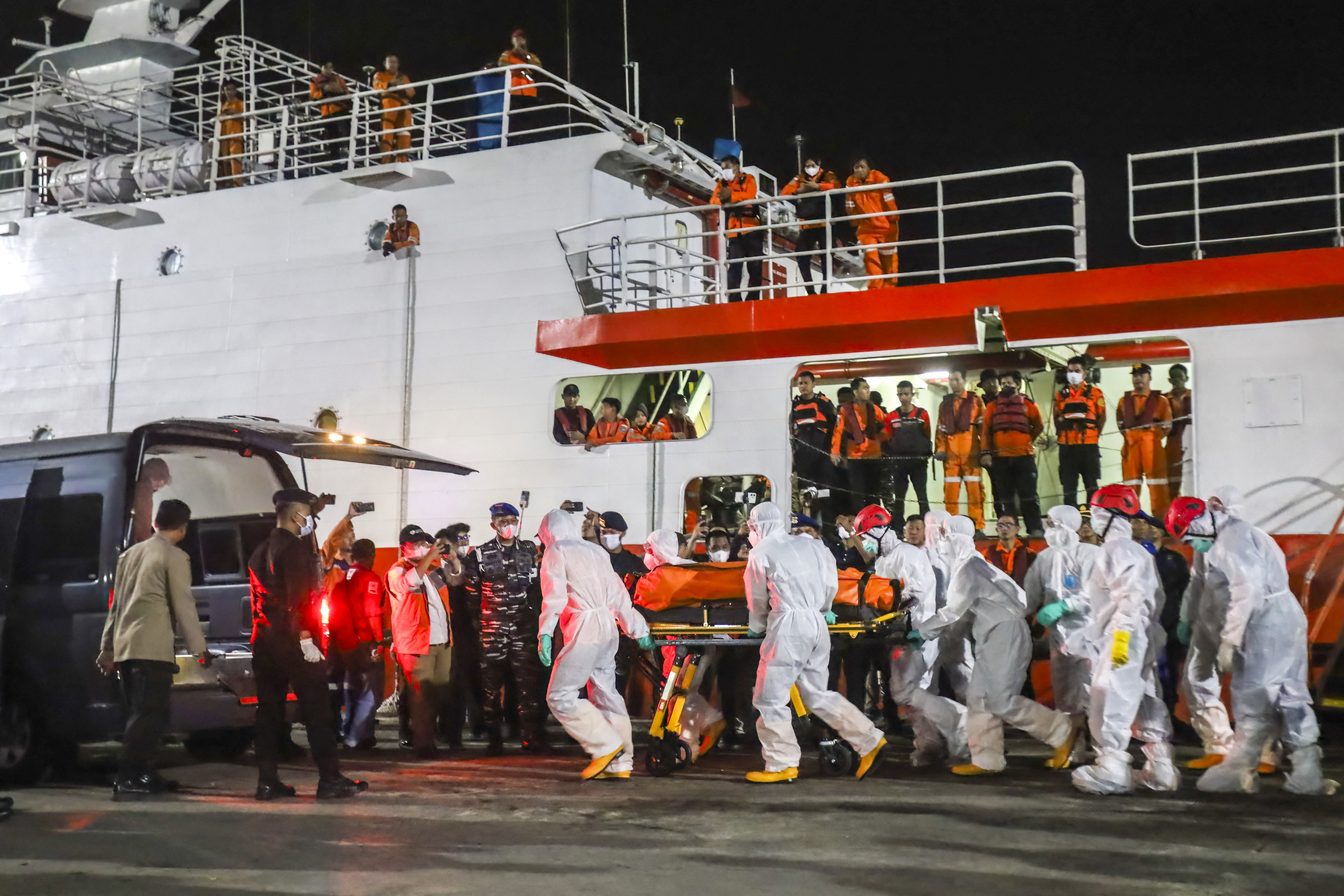 Joint evacuation team members carry one of three body bags containing victims of the Virgo Transport 8 ship accident upon arrival at Trisakti Port, Banjarmasin, South Kalimantan, Indonesia