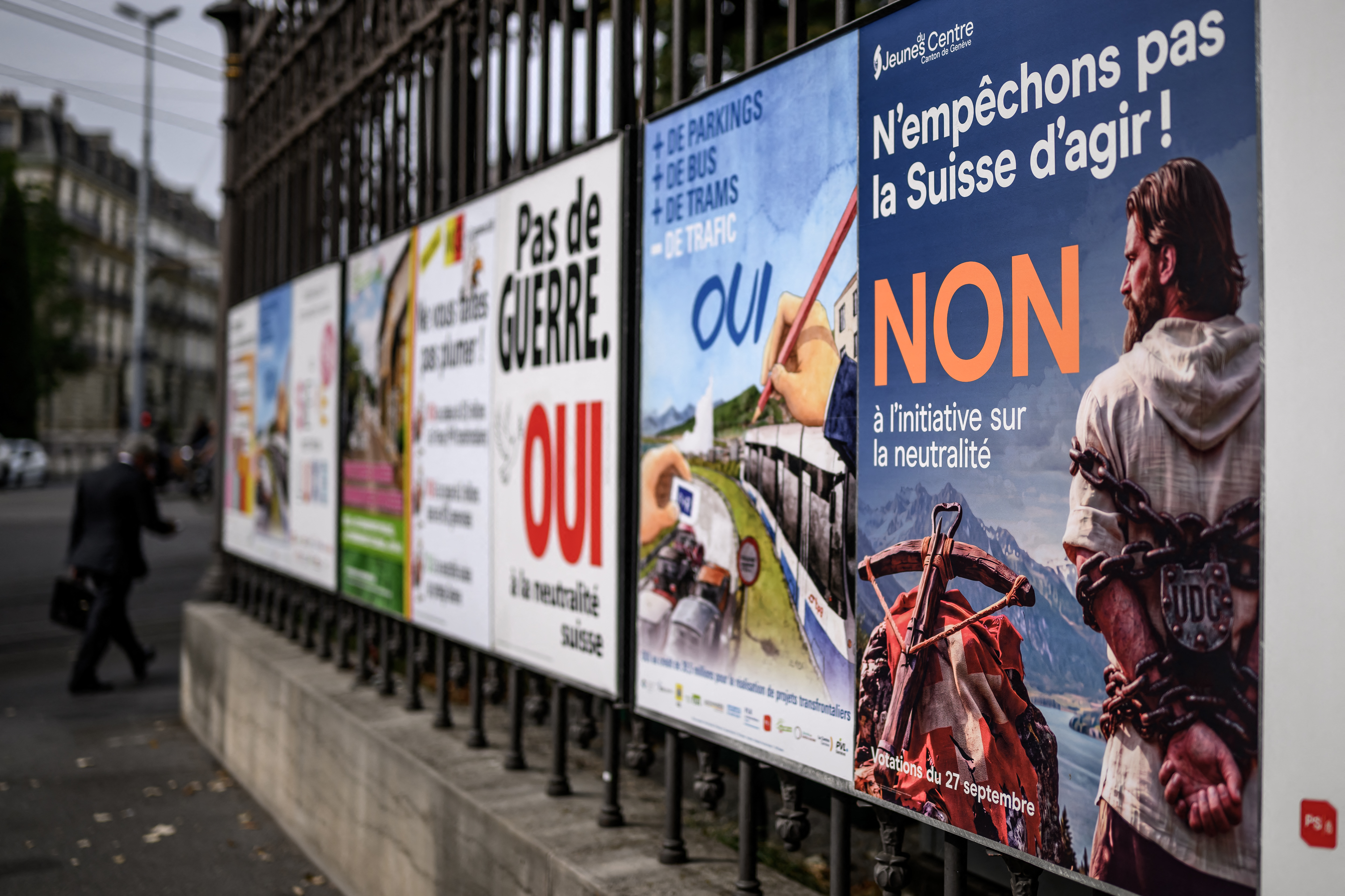 An electoral poster reading in French 'Let’s not prevent Switzerland from acting! No to the initiative on neutrality" representing the legendary Swiss folk hero William Tell is displayed alongside other campaign posters ahead of a nationwide vote, in Geneva, on September 17, 2026.