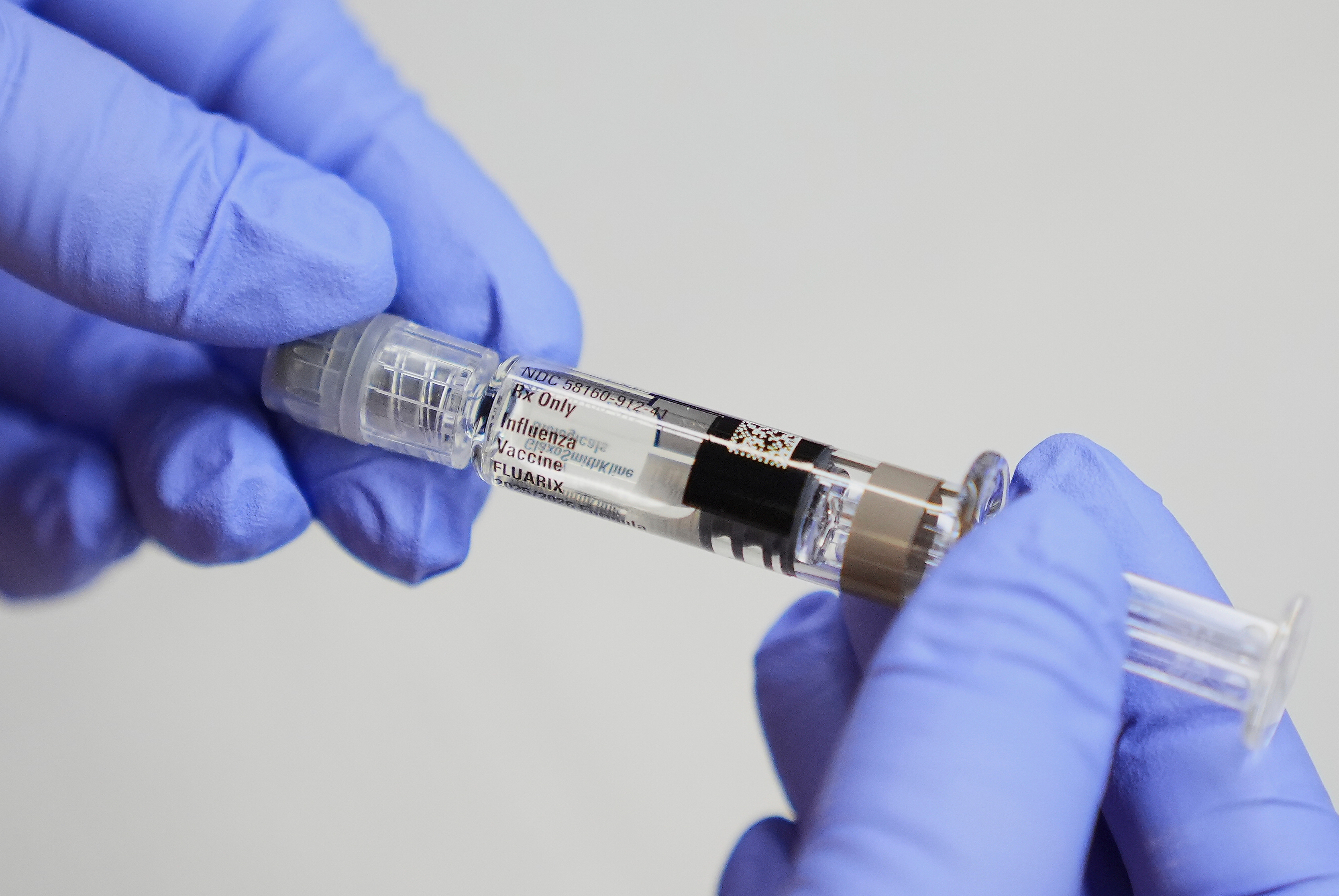 A certified medical assistant holds a syringe for a flu vaccine at a clinic in Seattle. [Lindsey Wasson/AP Photo]
