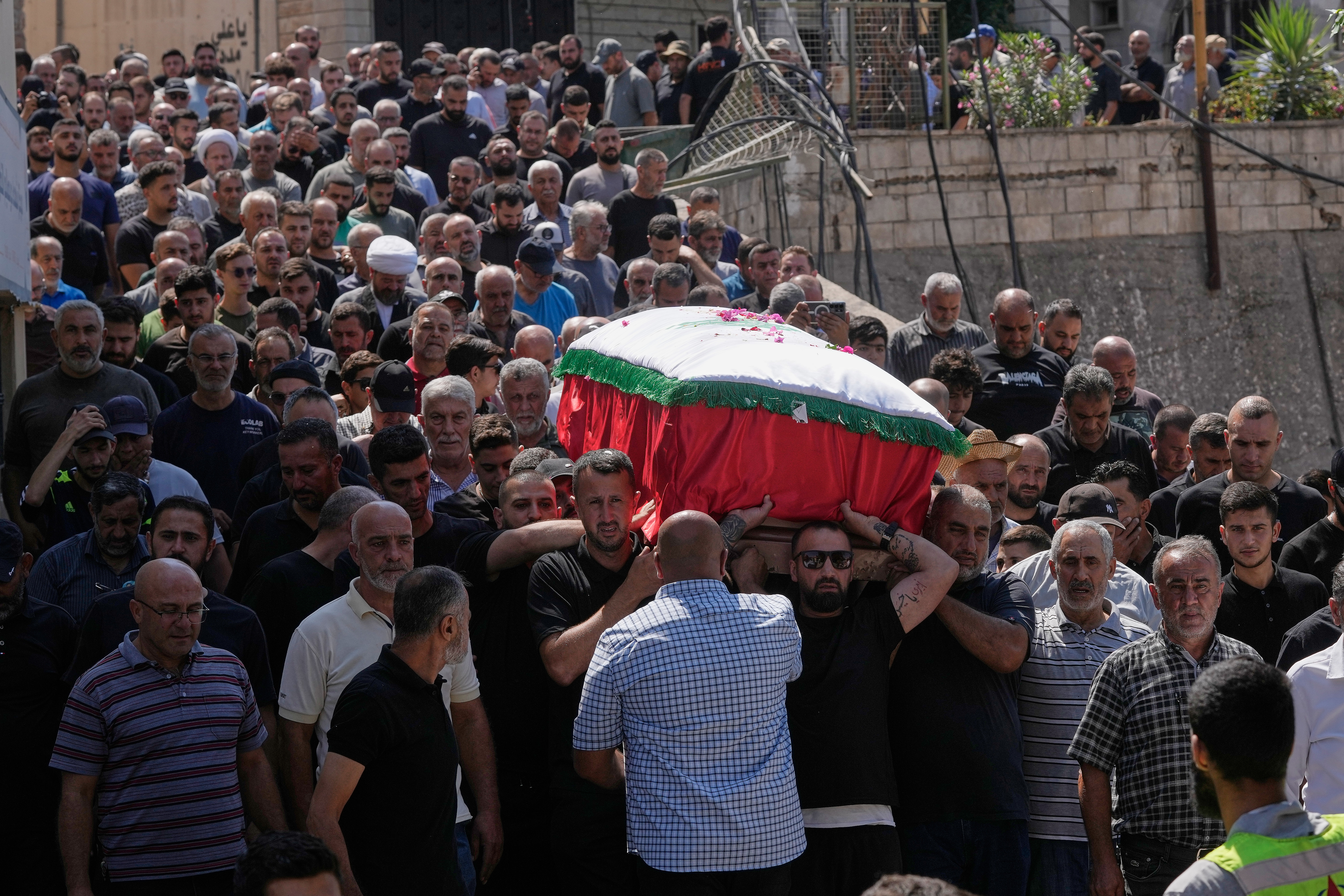Mourners carry the coffin of Saja Sharara, who was killed on Thursday in an Israeli airstrike, during her funeral procession in Arab Salim village, southern Lebanon [Mohammed Zaatari/AP Photo]