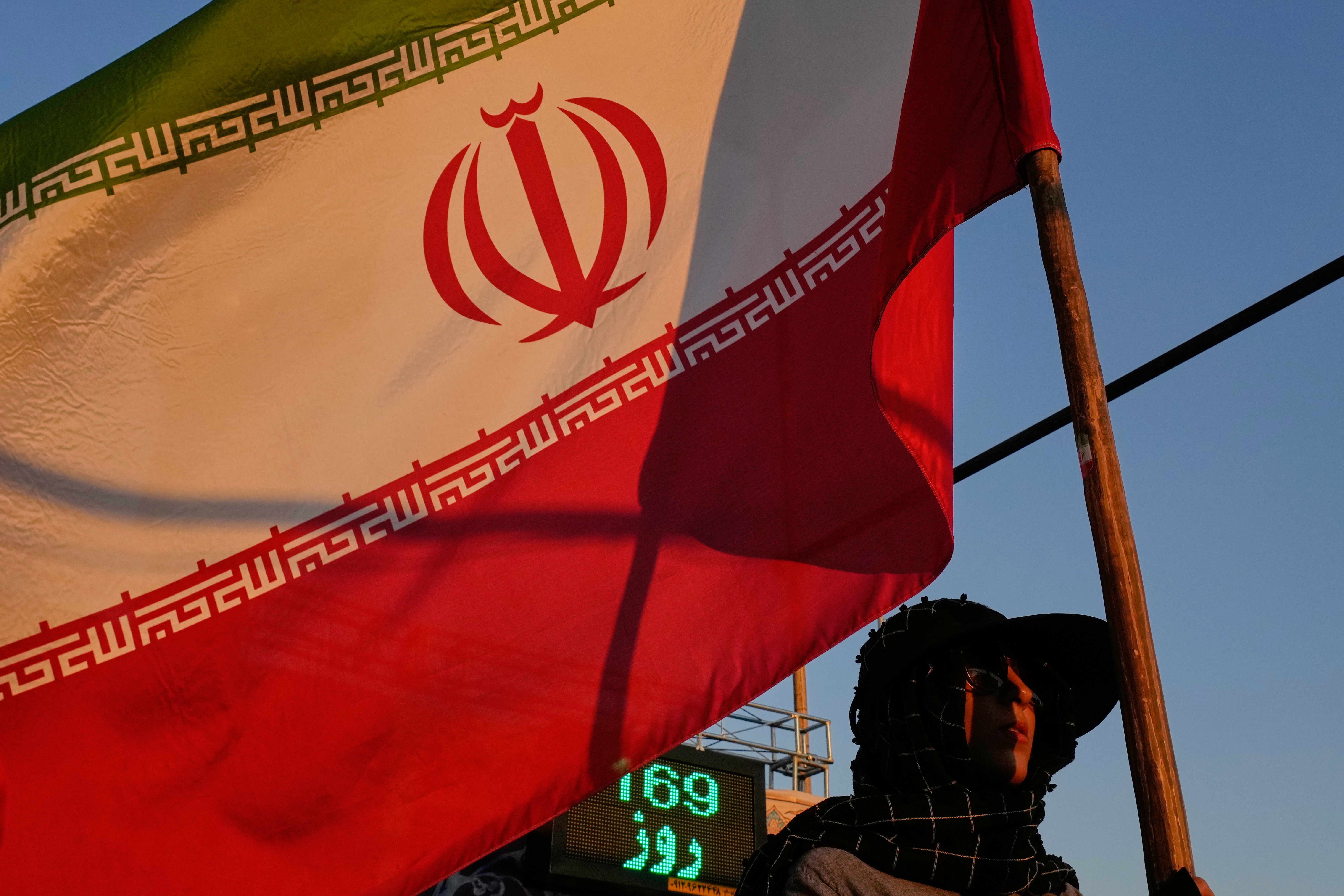 A woman holds an Iranian flag as part of a pro-government campaign in downtown Tehran, Tuesday, Sept. 15, 2026. (AP Photo/Vahid Salemi)