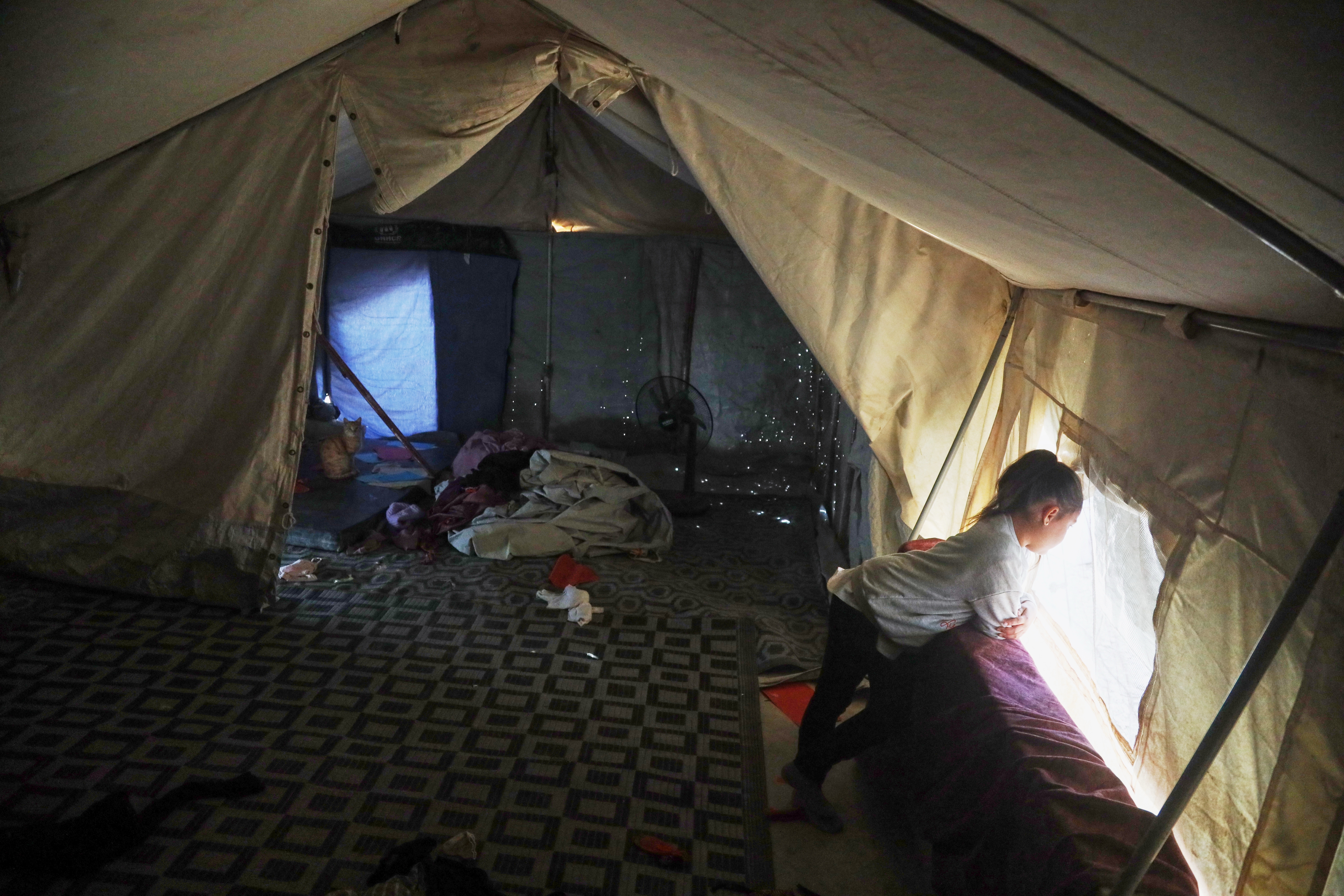 A young girl looks out from a tent in a section of the camp housing Australian relatives of suspected Islamic State militants who were returned because of unspecified procedural issues after an attempted repatriation by Syrian authorities Feb. 16, at Roj Camp in eastern Syria, Wednesday, Feb. 25, 2026. (AP Photo/Baderkhan Ahmad)