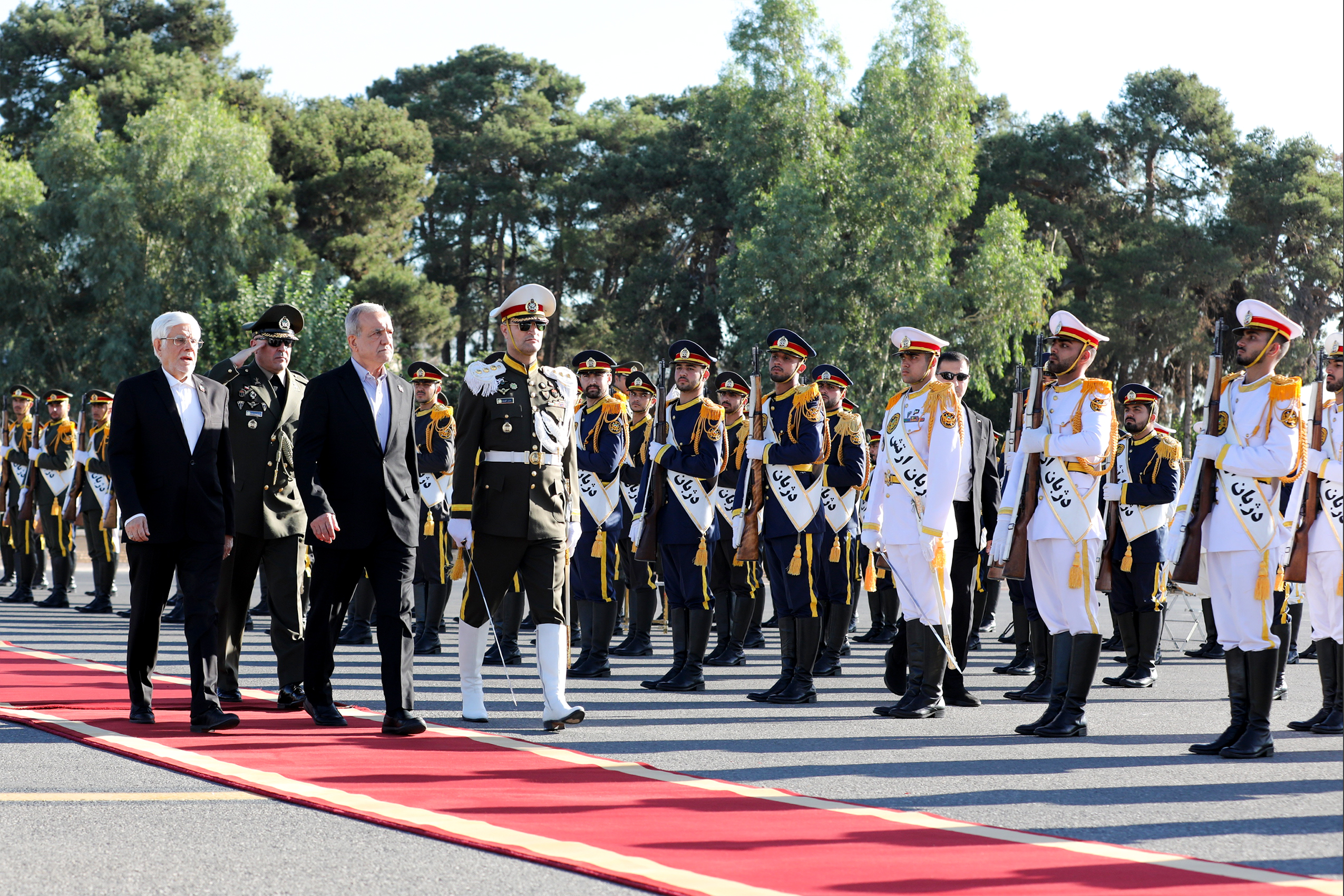 President Masoud Pezeshkian, third left, reviews an honour guard.