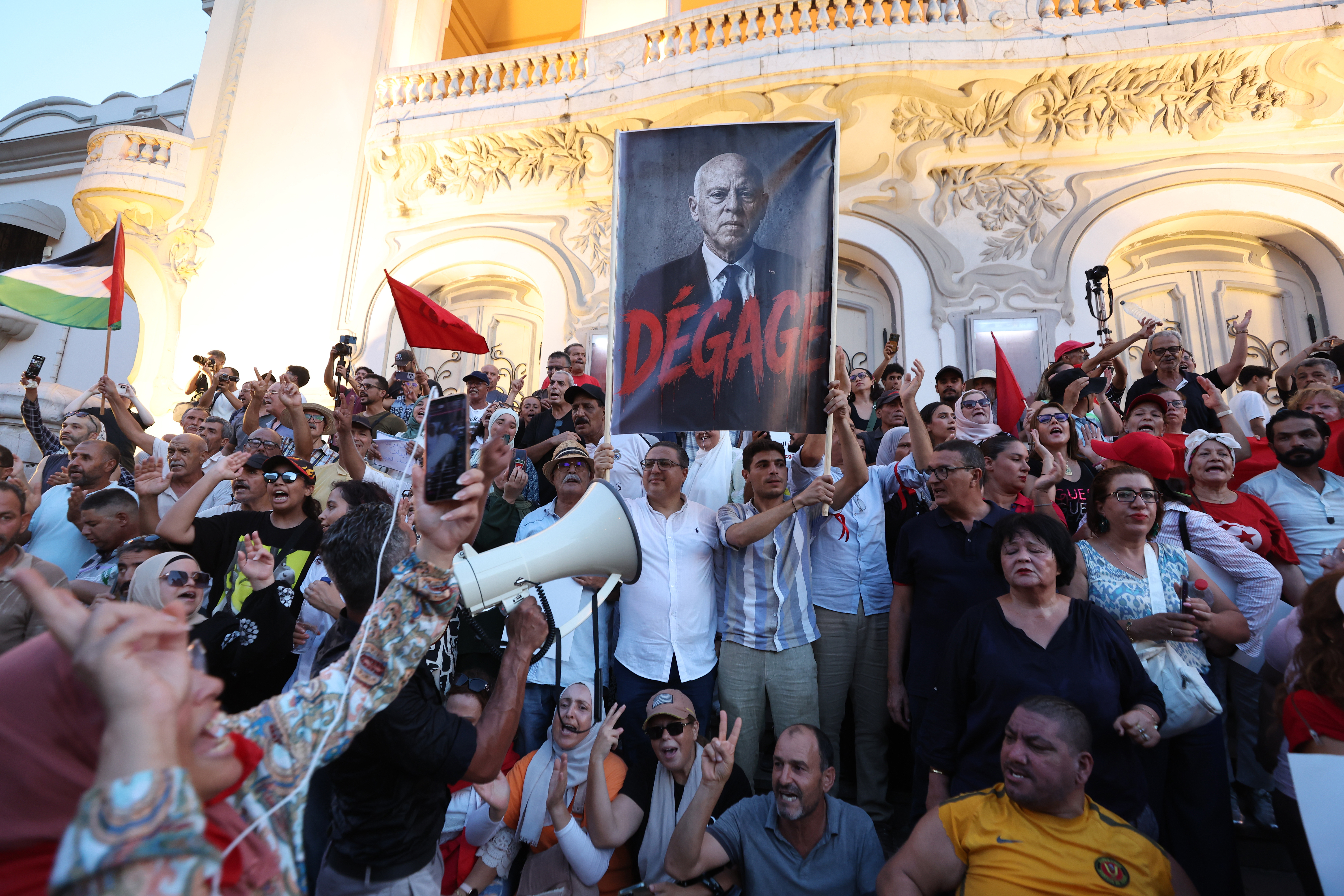 epa13181359 Tunisians hold the photo of Tunisian President Kais Saied and shout slogans during a demonstration against Saied and deteriorating living conditions, under the slogan, 'Enough of the absurdity, enough of the failure, enough of the injustice,' in Tunis, Tunisia, 20 August 2026. The demonstration, organized by the National Salvation Front and the Nafas movement, bought together opposition members and citizens denouncing the country's political, economic and social situation. EPA/MOHAMED MESSARA