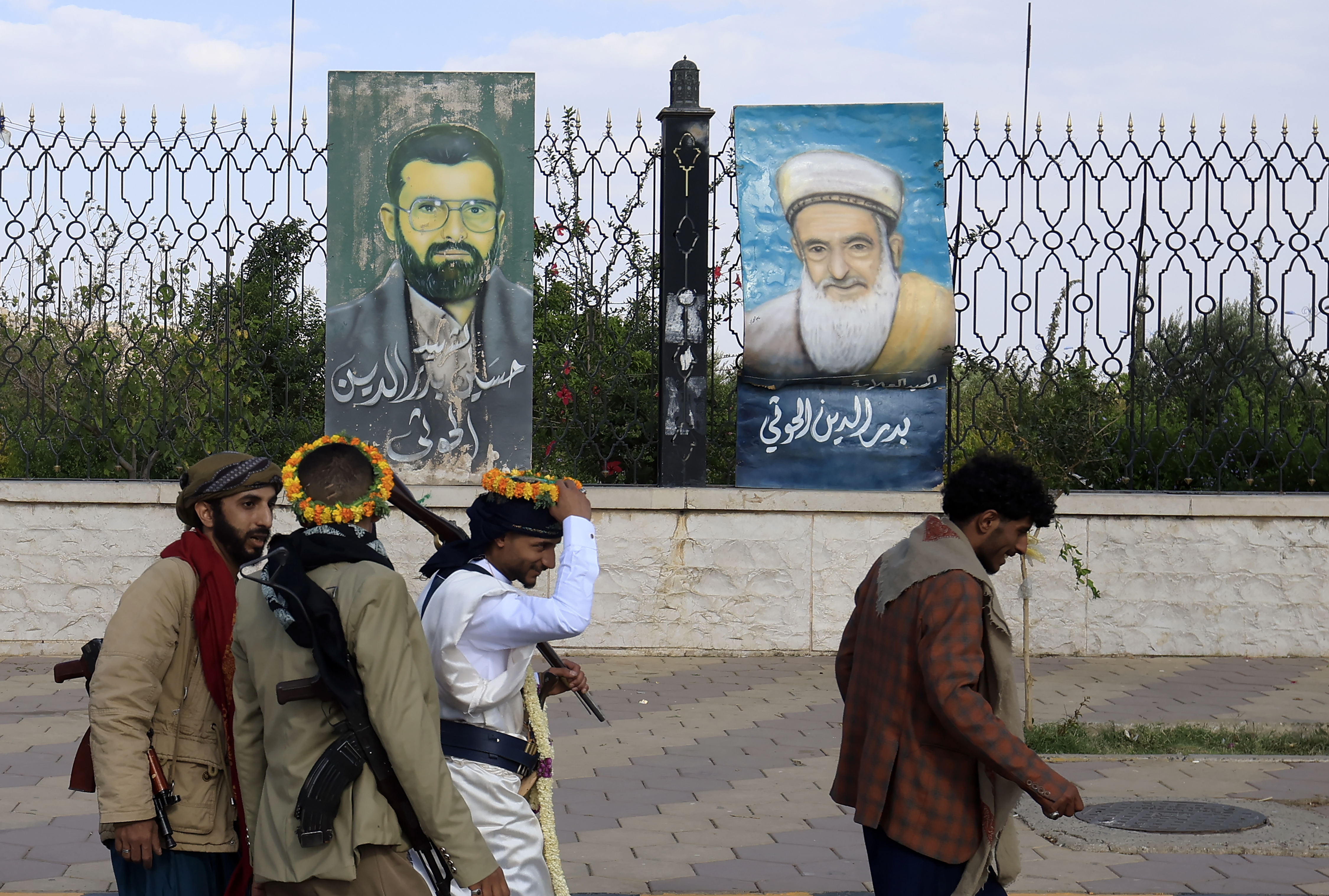 epa13221042 Armed people walk past paintings depicting late Houthi leaders on display on a fence in Sana'a, Yemen, 07 September 2026. United Nations Special Envoy for Yemen Hans Grundberg warned of grave consequences for civilians in Yemen due to the recent escalation of fighting between the Houthis and government forces, calling on the warring parties to prevent further escalation. EPA/YAHYA ARHAB