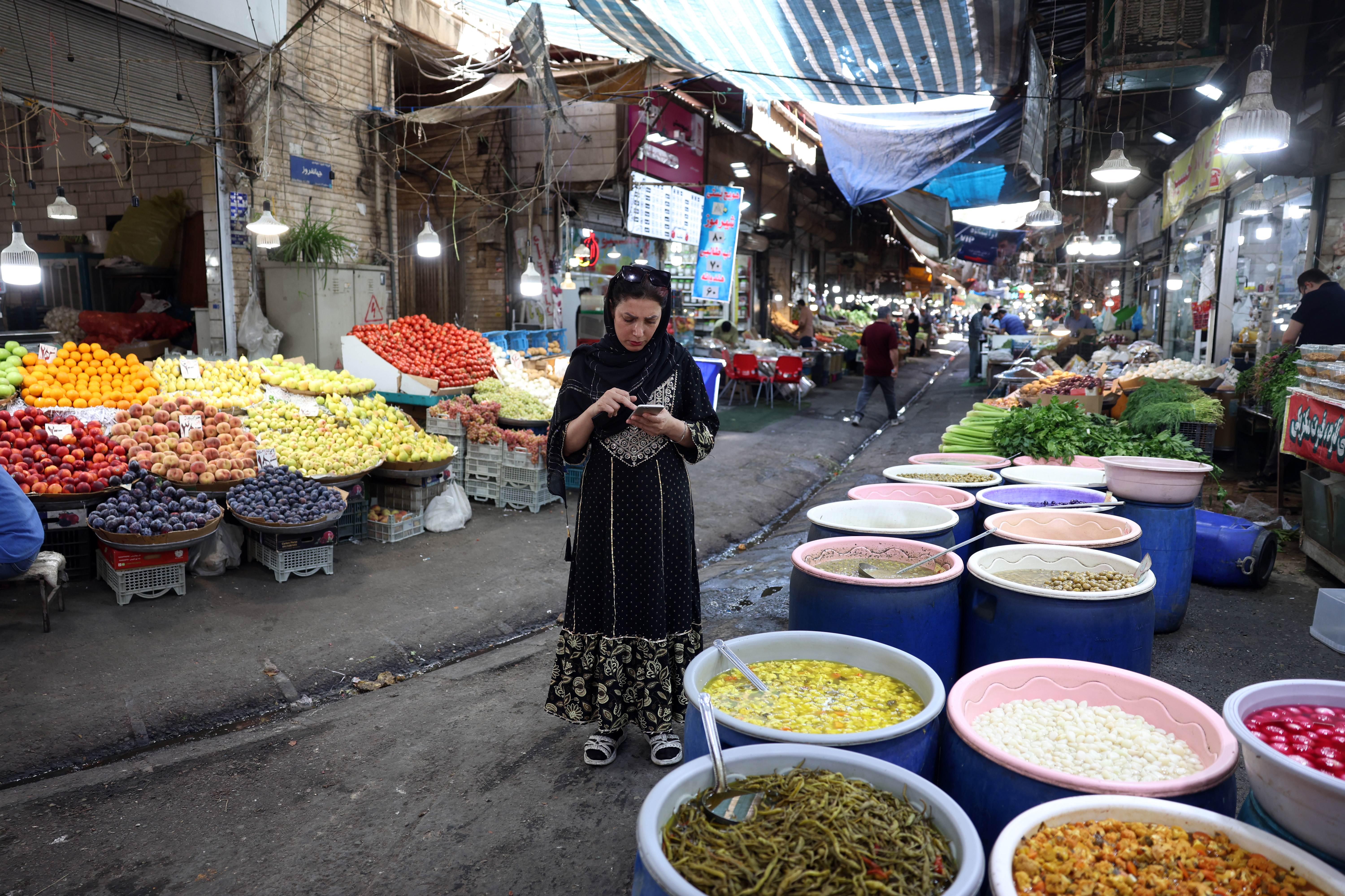 People go shopping in a bazaar in southern Tehran, Iran