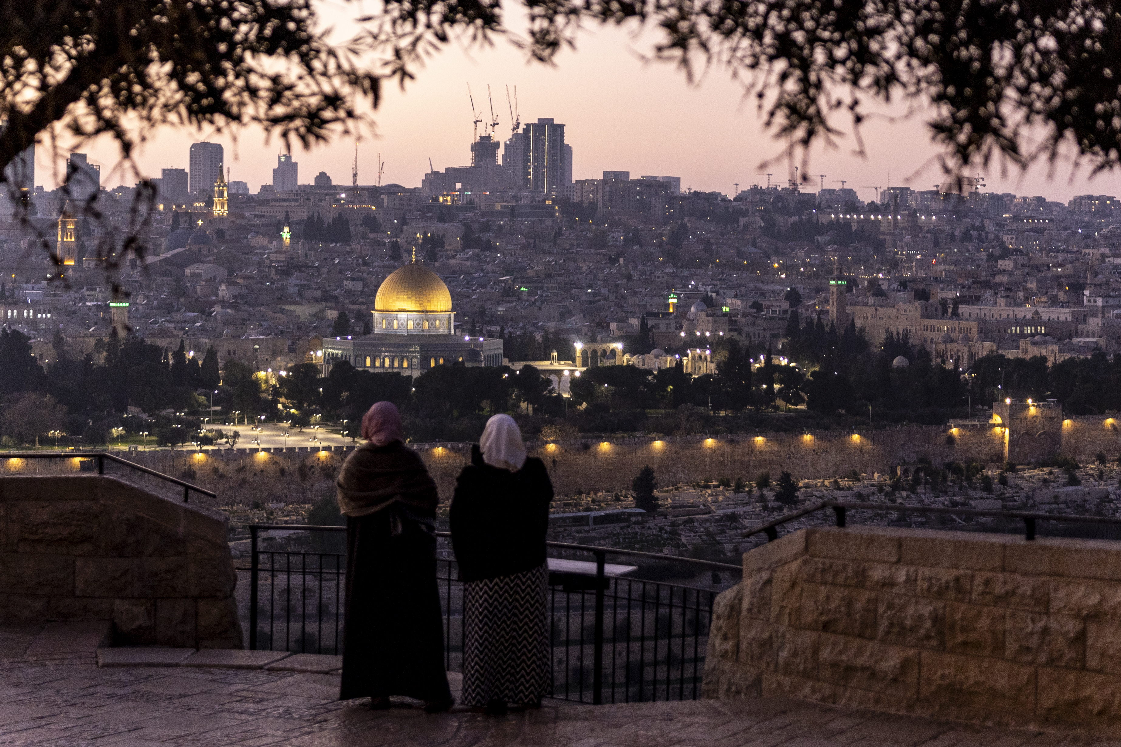 Palestinian women stand at Rekhavam Observation Point, with Al-Aqsa Mosque in the background, in Jerusalem