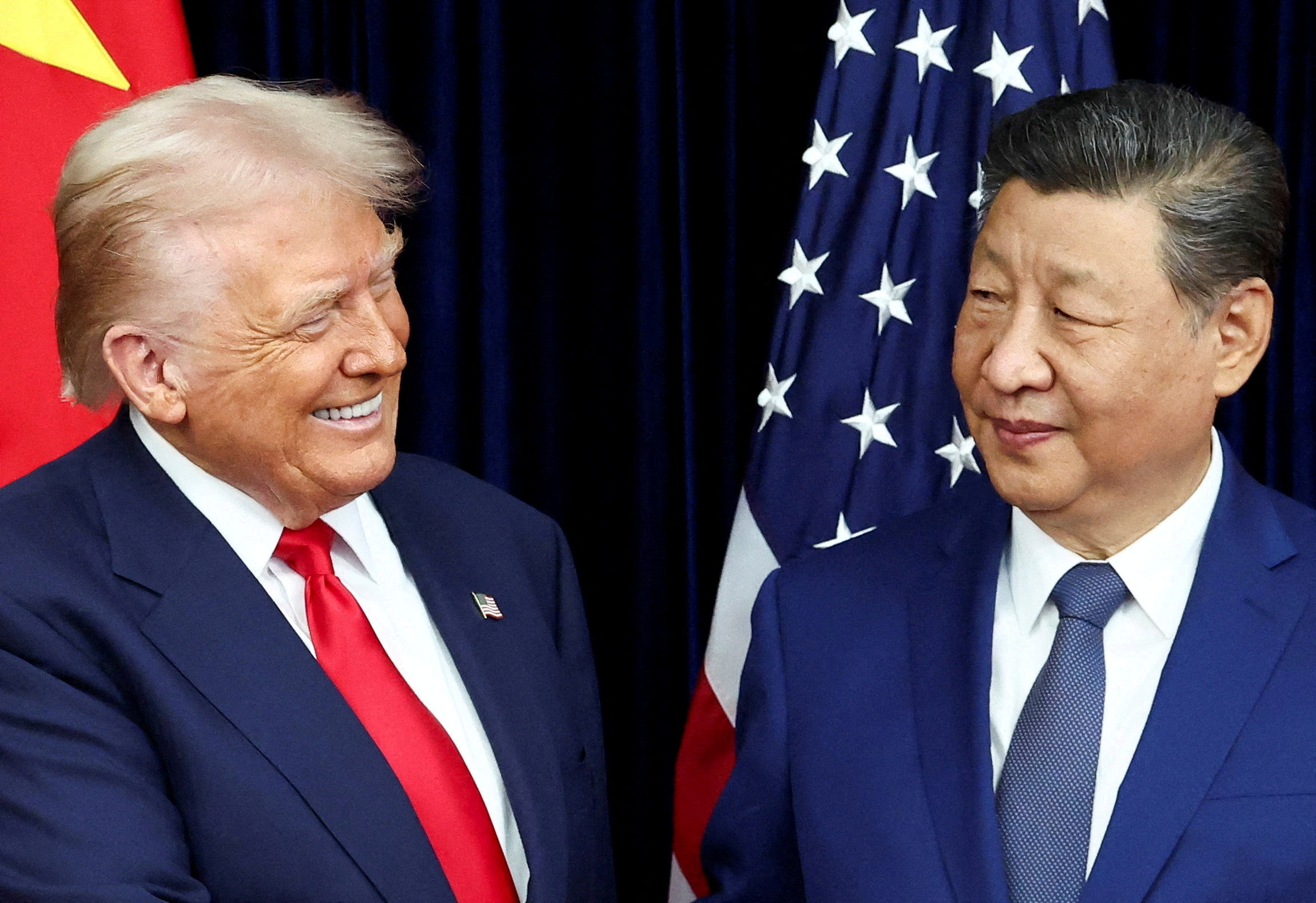 FILE PHOTO: U.S. President Donald Trump and Chinese President Xi Jinping react as they hold a bilateral meeting at Gimhae International Airport, on the sidelines of the Asia-Pacific Economic Cooperation (APEC) summit, in Busan, South Korea, October 30, 2025. REUTERS/Evelyn Hockstein/File Photo